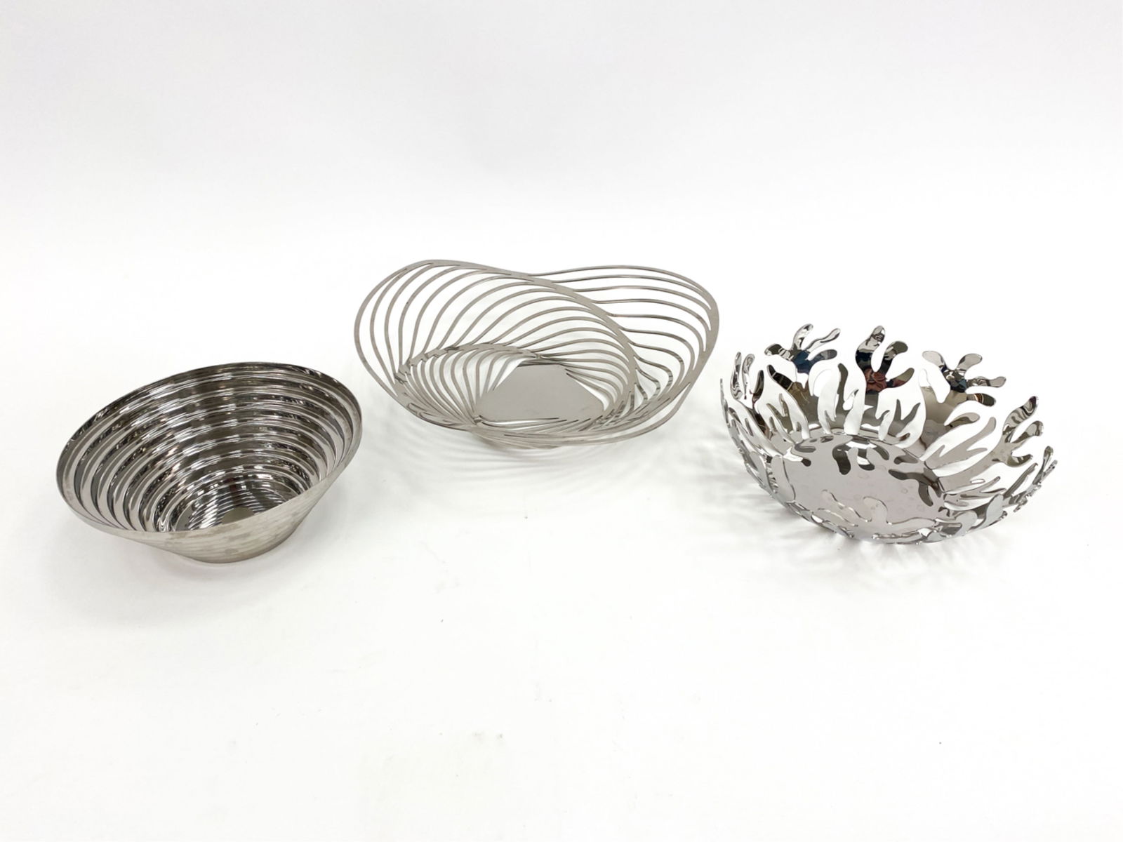 (3) DESIGNER ALESSI CENTERPIECE BOWLS: Trio of Alessi bowls. Grouping includes (1) c.1970s Alessi Maya fruit/centerpiece bowl designed by Giulio Confaloniere, (1) large Alessi Mediterraneo fruit/centerpiece bowl and (1) the largest is an A
