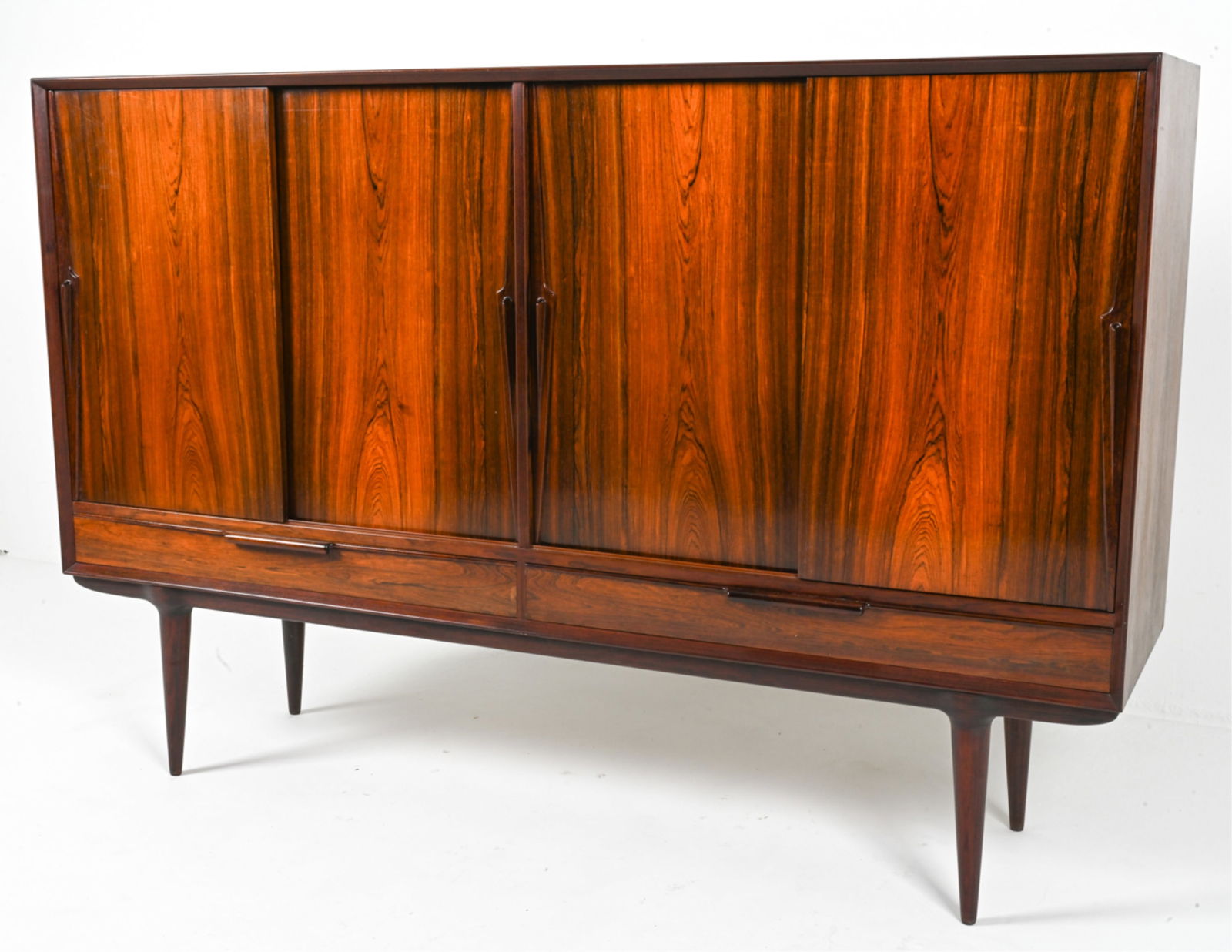 GUNNI OMANN OMANN JUN NO. 13 ROSEWOOD HIGHBOARD: Exquisite Model 13 tall sideboard in rosewood, featuring sculpted dart-form handles and adjustable interior shelves. Designed by Gunni Omann for Omann Jun. Denmark, c. 1960's. Dimensions: H 47.5" x W
