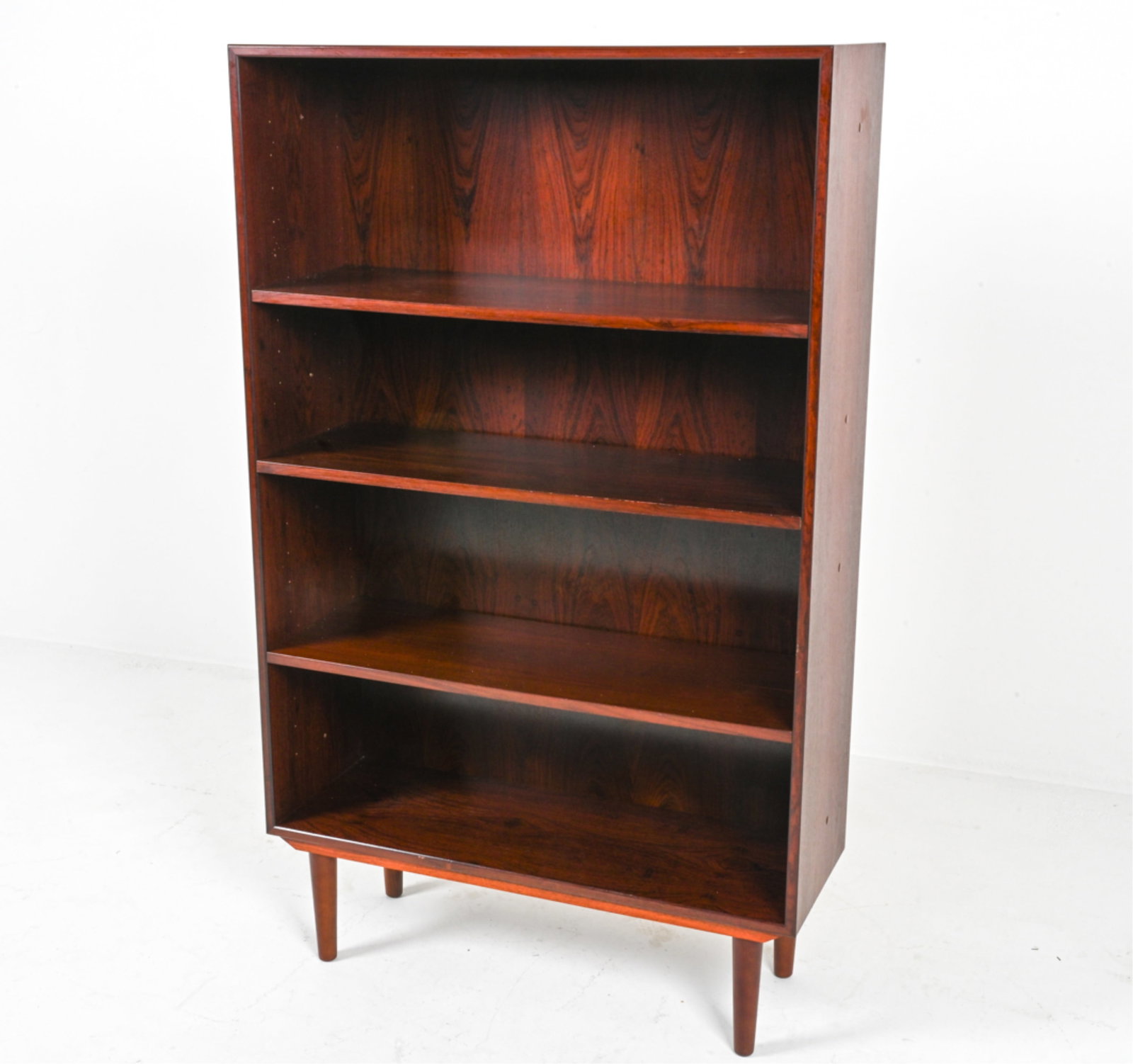 DANISH MODERN ROSWOOD BOOKCASE: Shelves adjustable. Circa 1960's-1970's. Dimensions: H 56" x W 33.75" x D 12". Condition: Legs do not appear to be original. Light scuffs, thin scratches. Water spots. DME 173