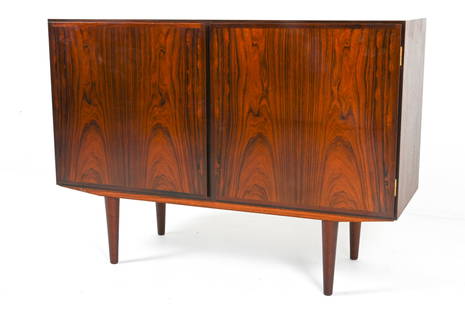 ATTR. GUNNI OMANN ROSEWOOD CABINET: Two-door credenza with adjustable shelves. Attributed to Gunni Omann for Omann Jun. Denmark, circa 1960's. Dimensions: H 33.5" x W 47" x D 17.25". Condition: Slight tobacco odor. Legs do not appear to