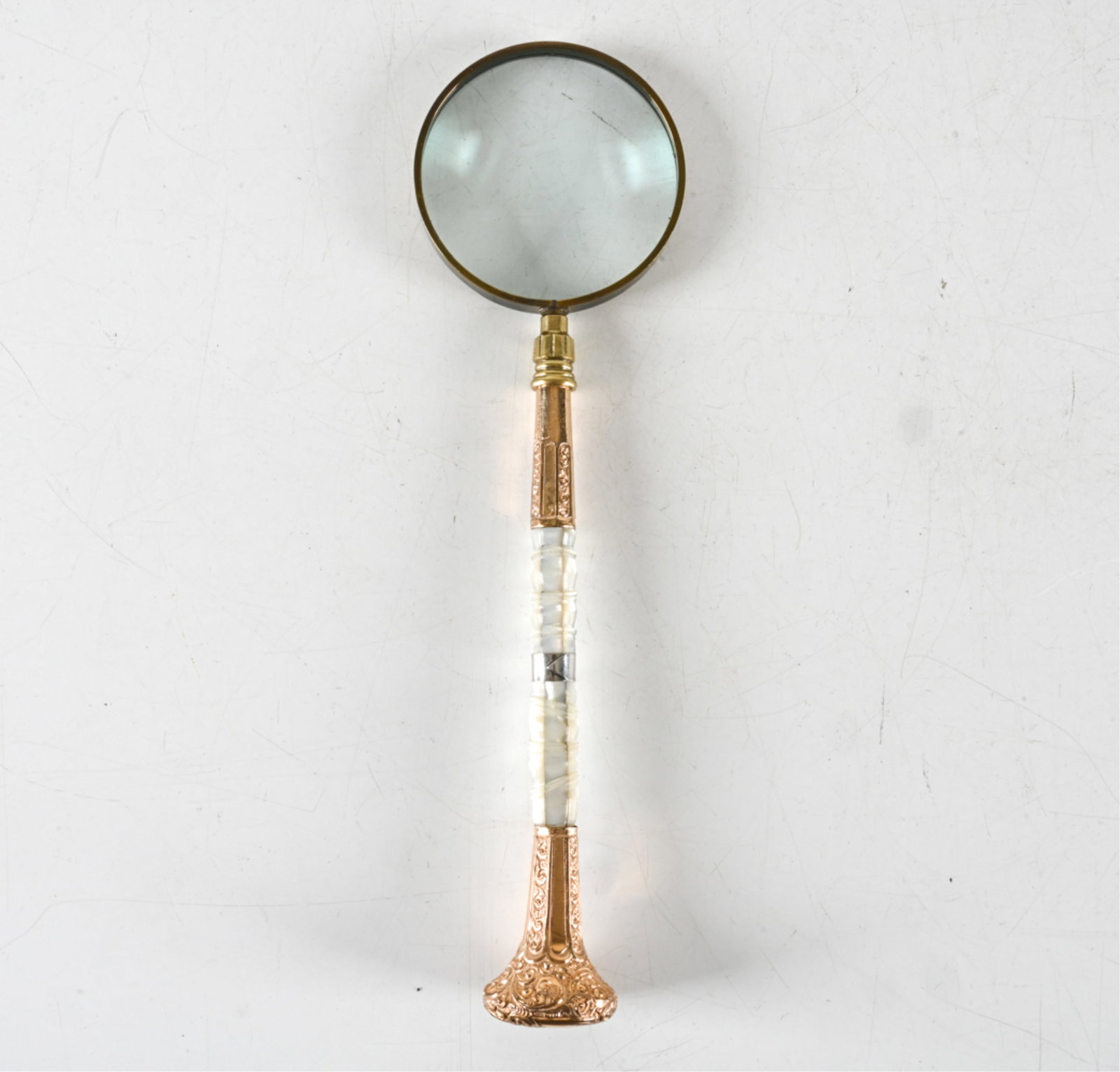 MOTHER-OF-PEARL & ROLLED GOLD MAGNIFYING GLASS: Likely adapted from a parasol handle. With silver band. 19th Century. Provenance: From the executive offices of the The Hit Factory recording studio in NYC, now in Danielle Germano’s personal collec