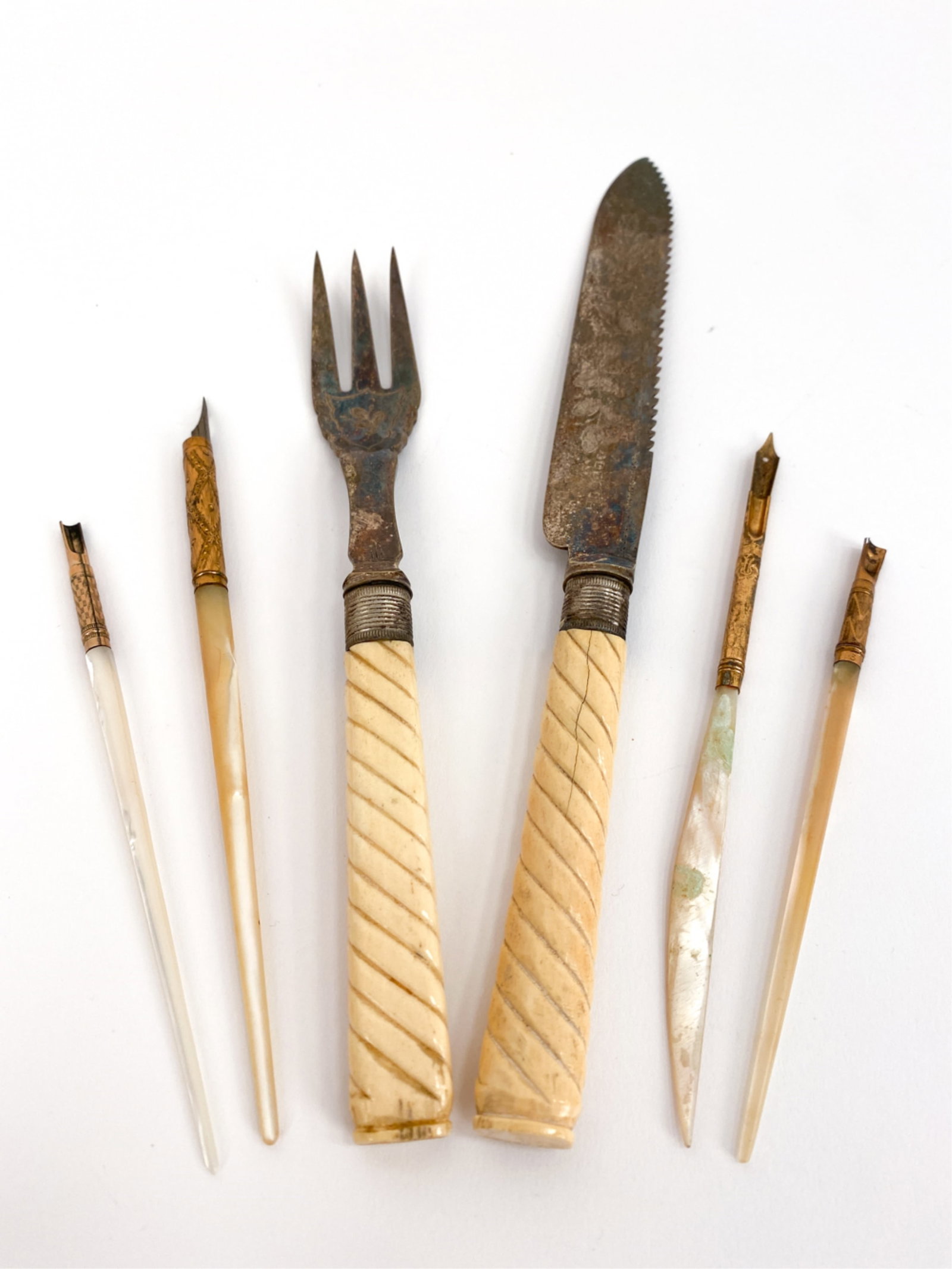 19TH C. DECORATIVE UTENSILS INCL. STERLING: Includes serving knife and fork marked British sterling, engraved surfaces and bone handles. 3 mother of pearl desk implements including pens and letter openers. Dimensions: (Knife) H " x W " x D " Co