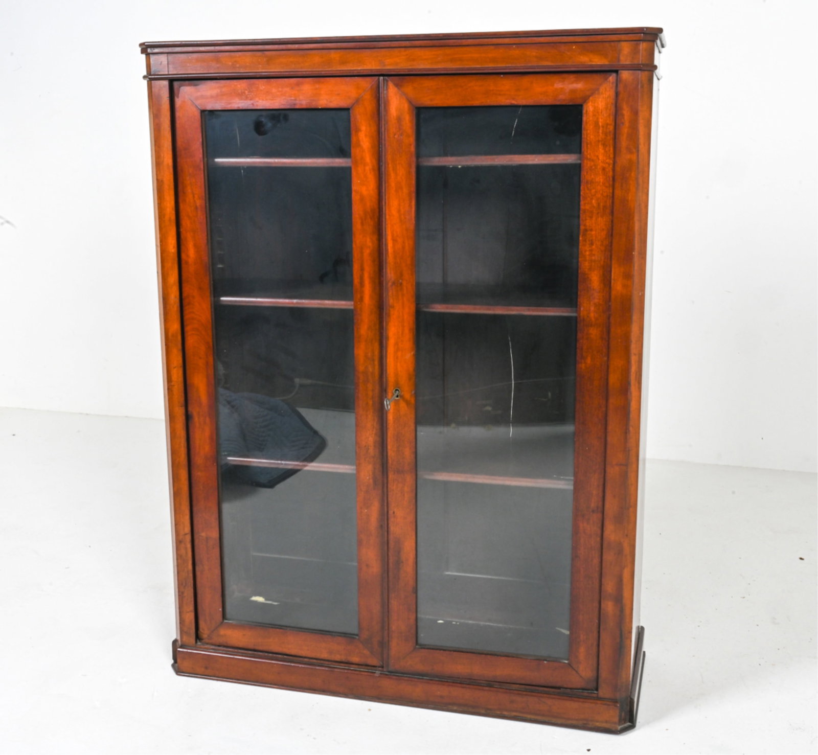 ANTIQUE FRENCH CABINET BY MAISON MERCIER FRERES: Mahogany cabinet case with locking glass doors, key included. Manufacturers mark on back. French, early 20th century. Dimensions: H "43 x W 32" x D 11" Conditions: Missing front two corner trim, A few