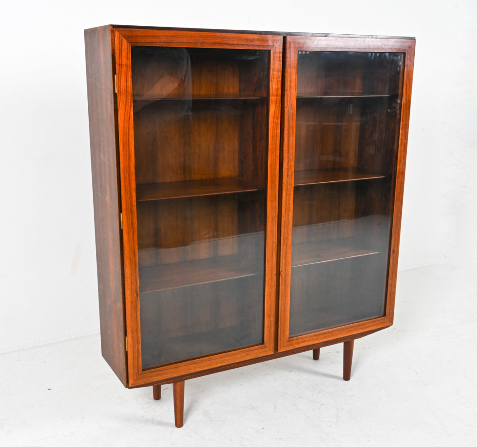 DANISH ROSEWOOD CABINET BY OMANN JUN: Model 9. Manufacturer's tag on back. Shelves adjustable. Denmark, c. 1960's-1970's. Dimensions: H 55.75" x W 47.25" x D 12". Condition: Legs do not appear to be original. Cabinet presents very well ov