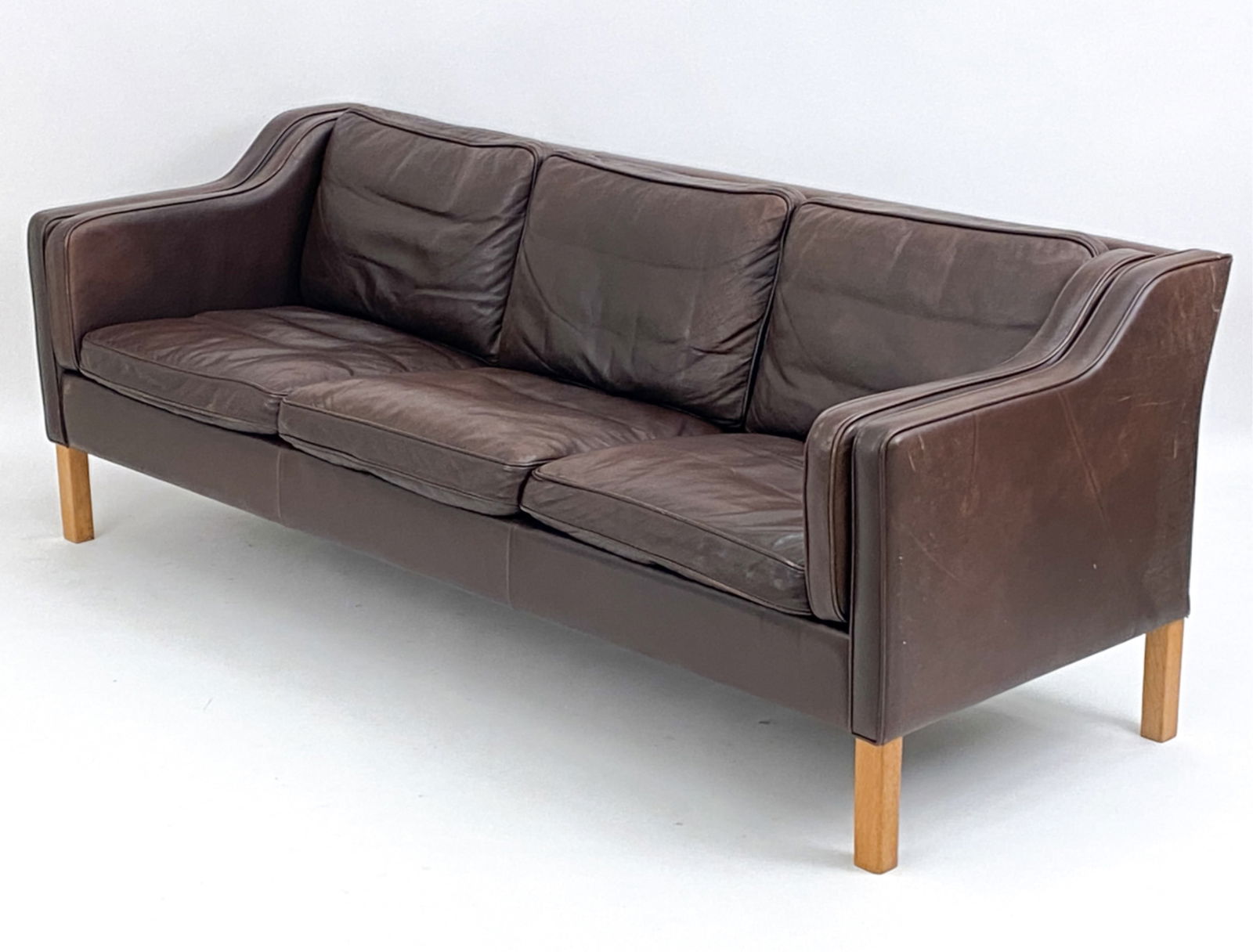 MOGENS HANSEN LEATHER AND OAK 3 SEATER SOFA: Danish. c. 1970. Dimensions: H 31" x W 80.5" x D 32" x SH 17" Condition: Some light creasing to leather including a couple scratches. D034