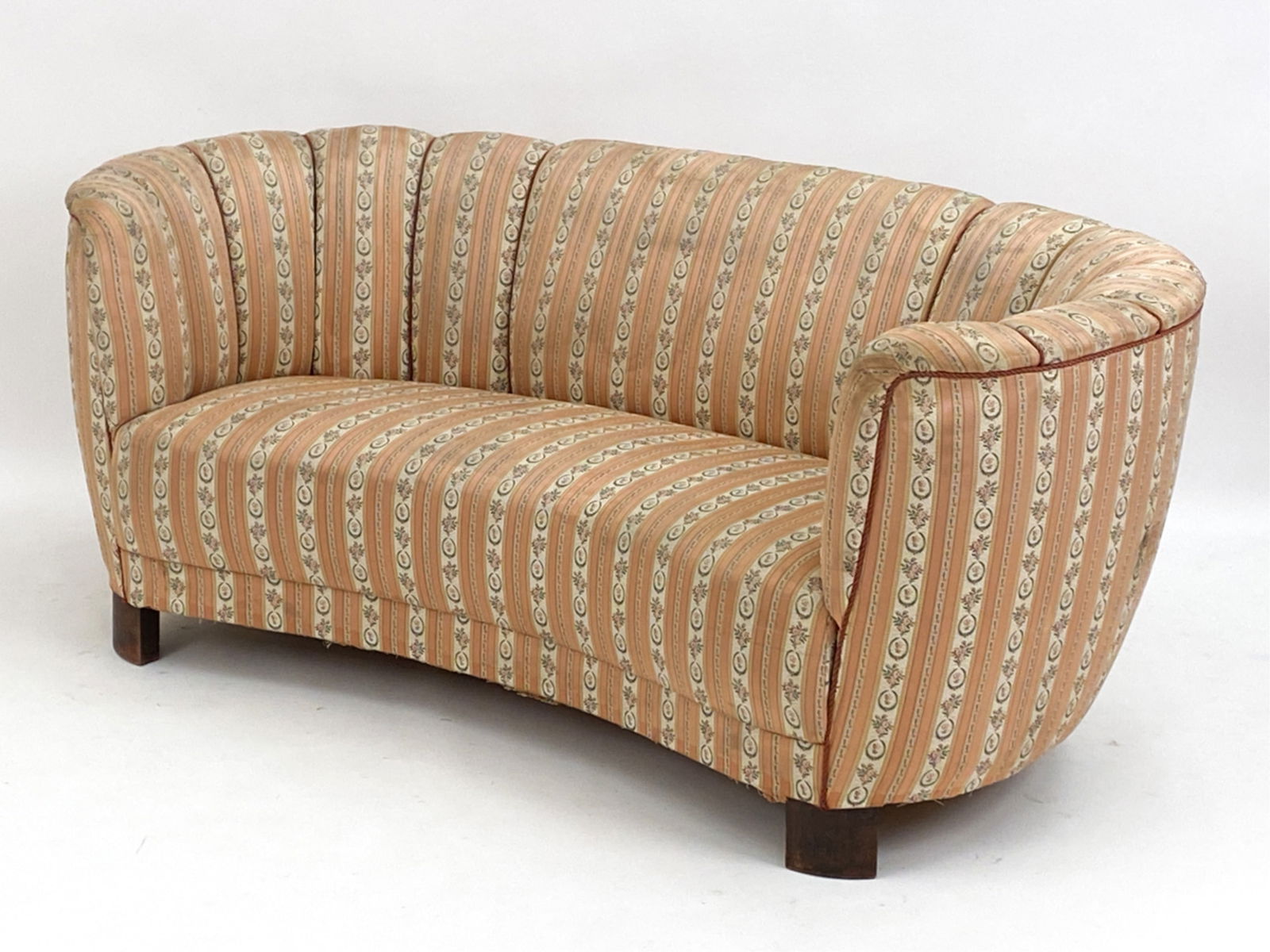 DANISH BANANA COCKTAIL SOFA FOR SLAGELSE, C. 1940: Viggo Boesen for Slagelse cocktail sofa. With floral and rope designed upholstery and stained Beechwood legs. Dimensions: H 28.25" x W 68" x D 32" x SH 15.5" Condition: Some fading and discoloration.