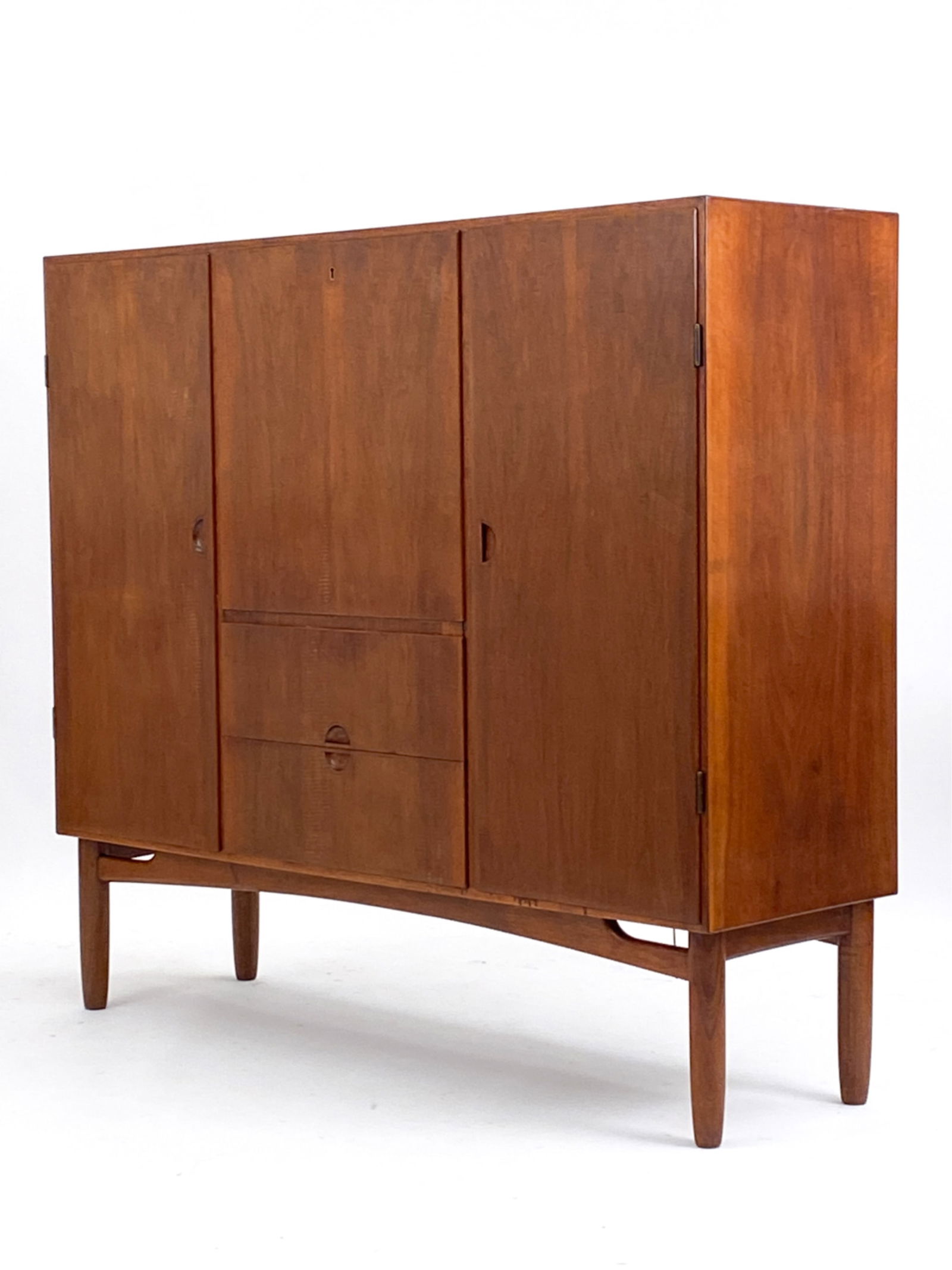 MID-CENTURY DANISH TEAK OMANN JUN STYLE HIGHBOARD: Highboard/credenza in the style of Omann Jun. With 2 drawers with felted interiors and middle door with a mirror and inscriptions. Apparently unsigned. Key included. Dimensions: H 52.5" x W 59" x D 18