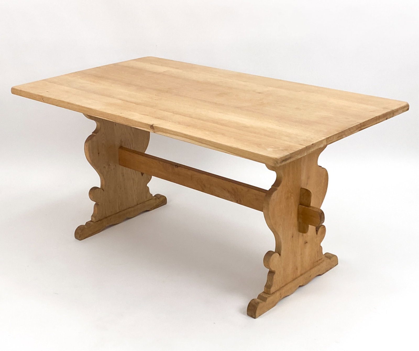 HENNING KJERNULF OAK TRESTLE TABLE: C. 1970. Dimensions: H 29" x W 59" x D 33.25" Condition: Showing some superficial finish wear consistent with age. Loss to wedge pin causing it to sit deeper in the slot of the stretcher. D212