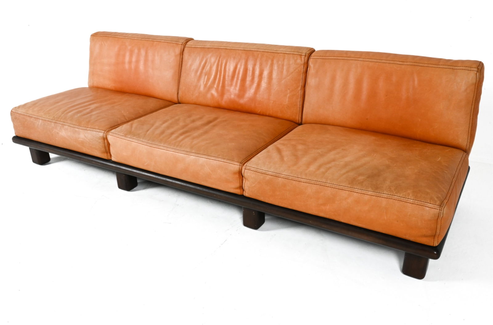 LEATHER SOFA IN MANNER OF CASINA C.1970'S: Most likely Italian. Dimensions: H 28" x W 94.5" x D 33" x SH 14.5". Condition: Some wear to leather, sun fading. Some scuffs to wood. PG045