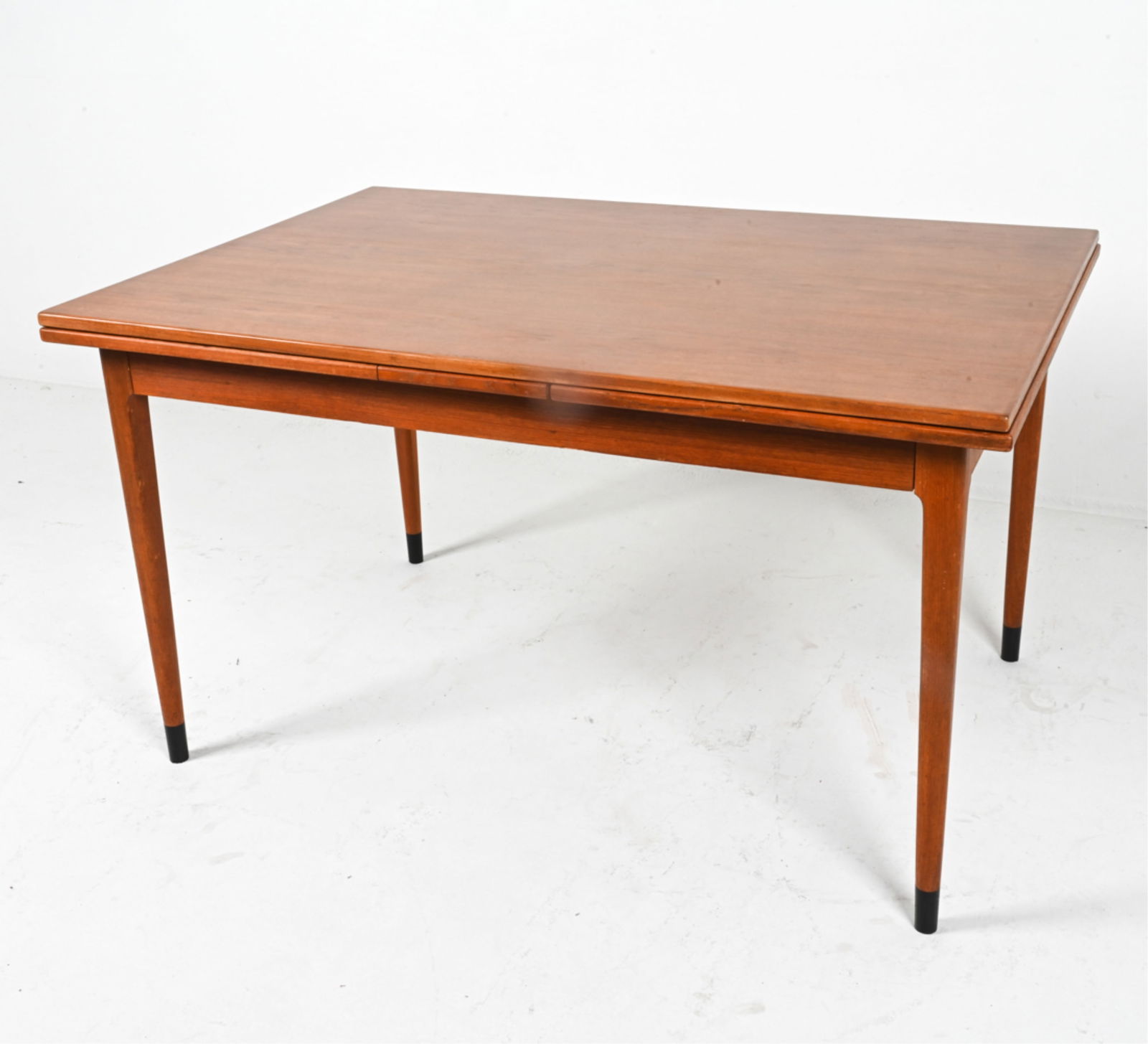 TEAK EXPANDING DINING TABLE BY NEILS OTTO MOLLER: For J.L. Moller. Table top expands with (2) leaves inside. Denmark, circa 1950's. Dimensions: H 29" x W 51.25" x D 35.5" . Leaf W 21". Condition: Minor scuffs and scratches. Presents well overall. PG1
