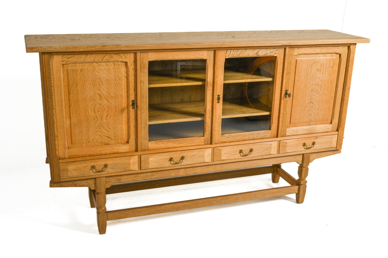 HENNING KJAERNULF DANISH OAK SIDEBOARD: Tall sideboard in quarter-sawn oak, featuring glazed display doors and raised drawer fronts with sculpted facets. Designed by Henry (Henning) Kjaernulf; Denmark, c. 1970's. Keys included. Dimensions: 