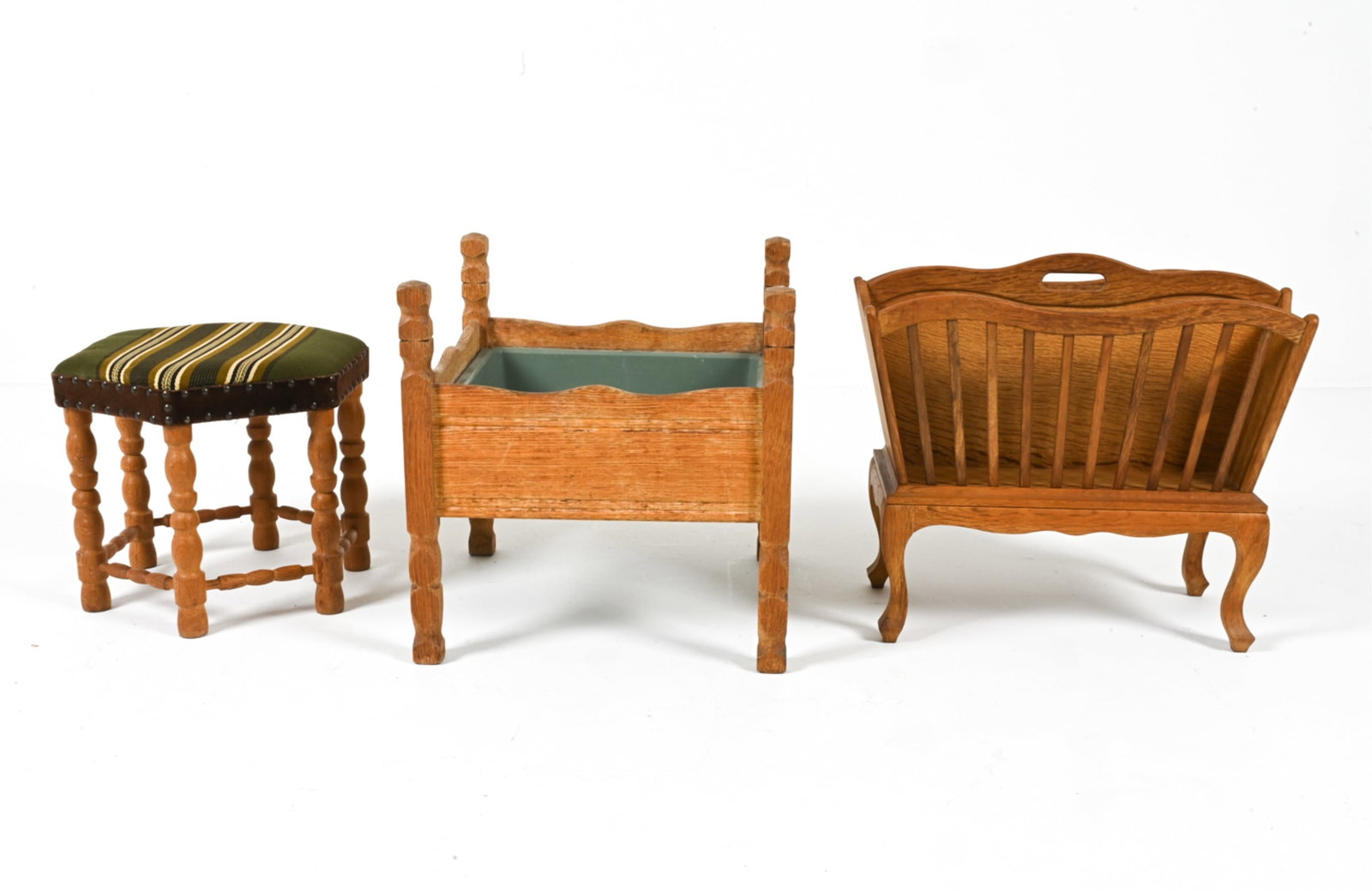 OAK FURNITURE TRIO IN THE STYLE OF KJAERNULF: Includes (1) footstool, (1) magazine rack, and (1) planter. In the manner of Henning Kjaernulf. Scandinavian, c. 1960's-1970's. Dimensions: Rack H 19" x W 20.5" x D 10". Condition: Planter has signs o