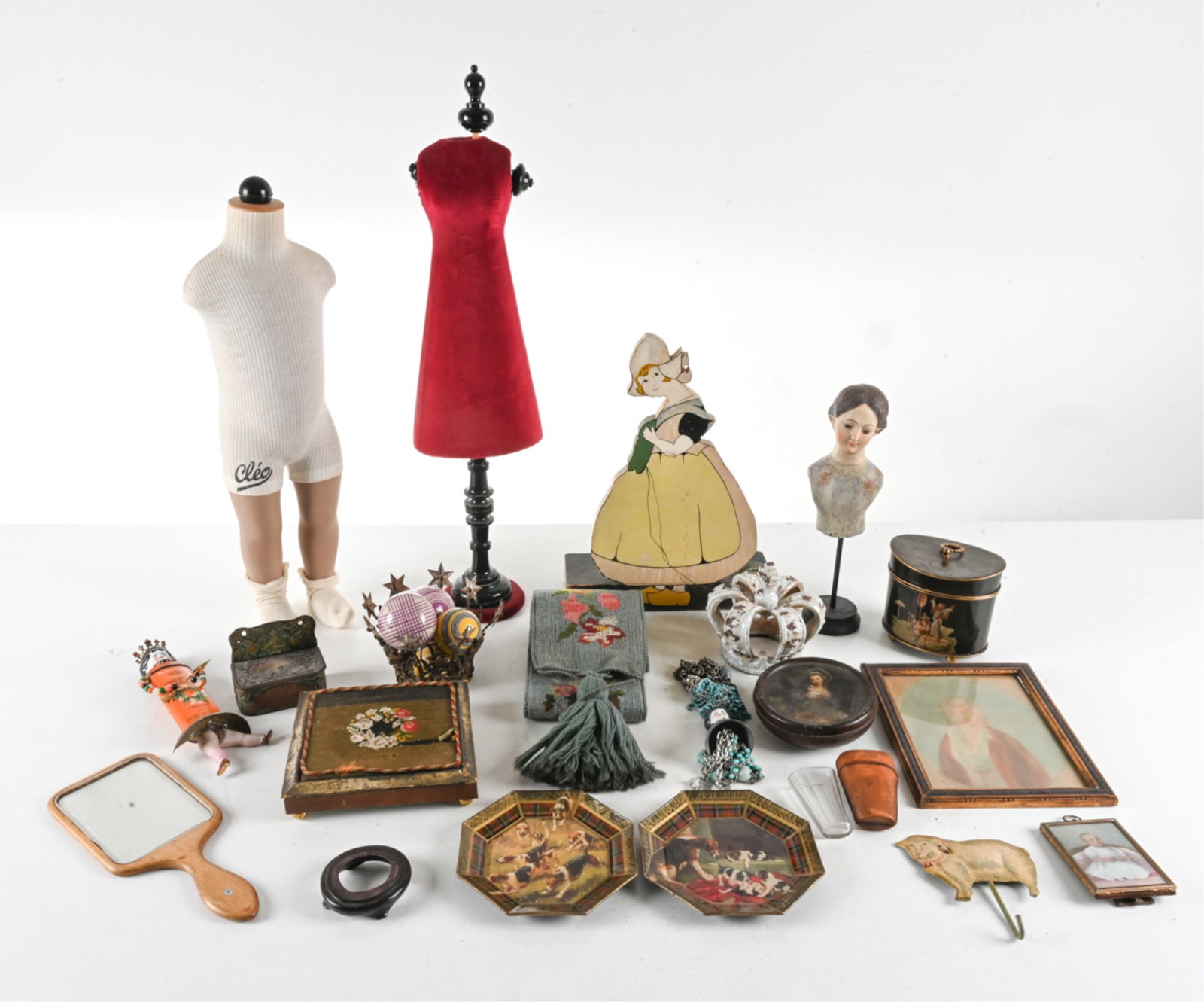 ECLECTIC VINTAGE & ANTIQUE DECORATIVE GROUPING: Including an antique needlepoint sash and trivet; toleware biscuit tins, (2) reverse-decorated glass plates by Durwin Rice, (2) petite mannequin dress forms, a carved and painted wood female bust, (4)