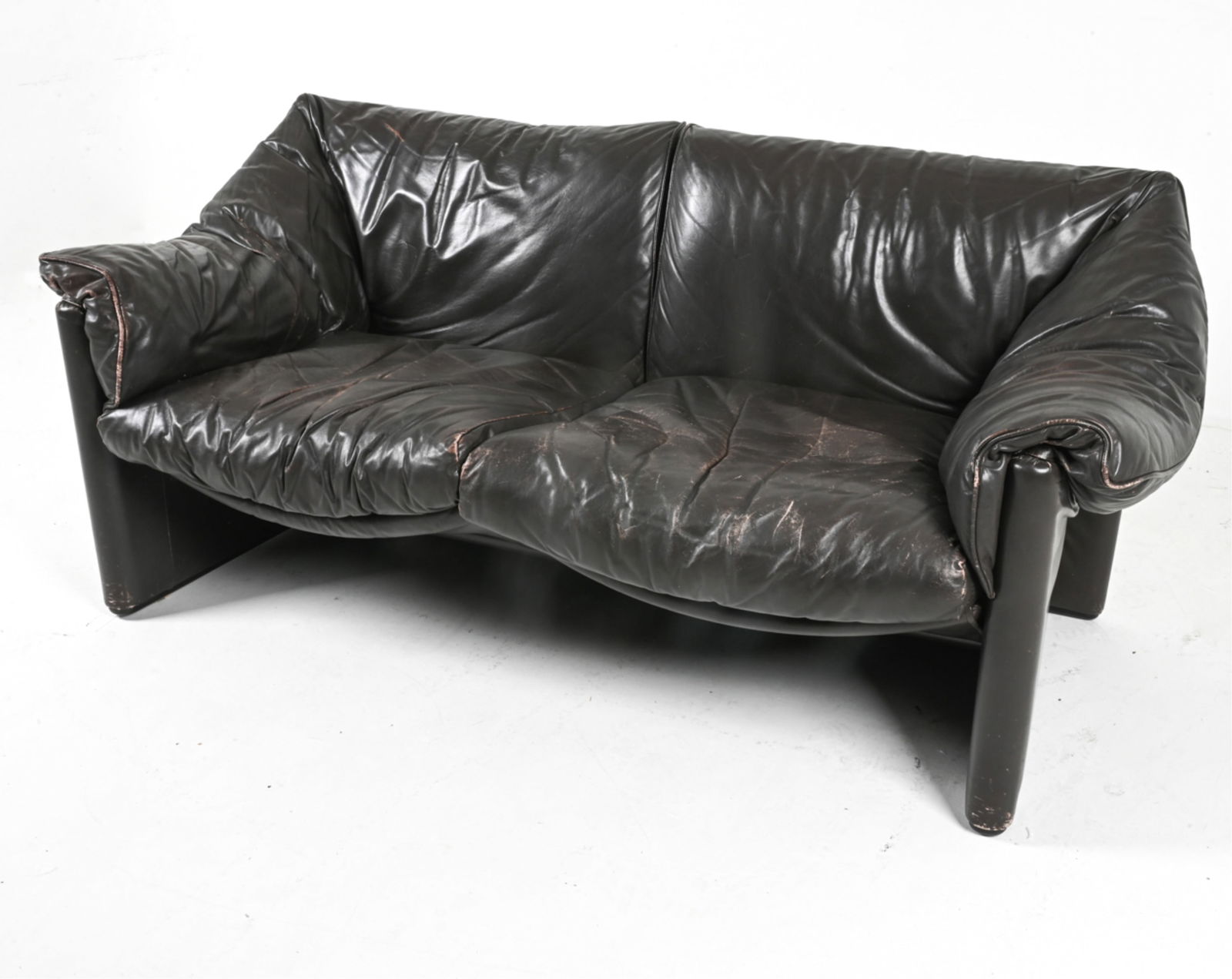 'BABALAO' LEATHER SOFA BY VICO MAGISTRETTI: For Probjeto-Cassina. Brazil, circa 1970's. Dimensions: H 28.75" x W 64" x D 31.25" x SH 17". Condition: Signs of wear to leather, some drying and flaking along seams, cushions. Some scratches. Wear c