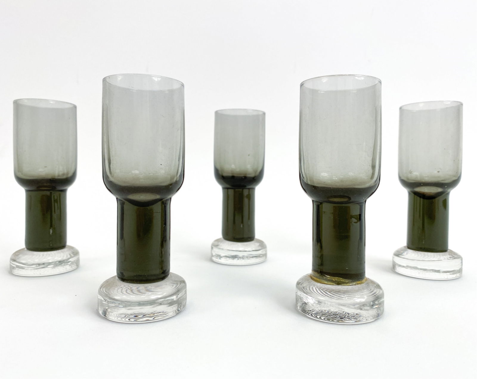 (5) GORAN WARFF FOR PUKEBERG CORDIAL GLASSES: (5) Swedish Mid-Century smoke color cordial glasses designed by Goran Warff circa 1960s. Dimensions: H 4.25" x Dia. 1.5' Condition: No issues to note. Surface dust.