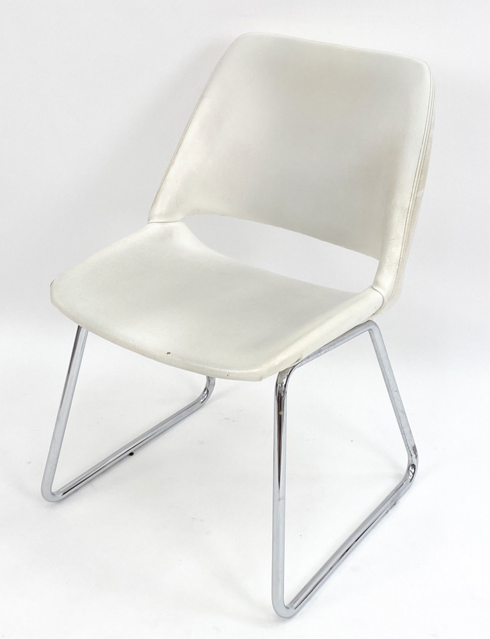MODERNIST STENDIG SLED-BASE CHAIR: Vintage modernist side chair Eero Aarnio style. Faux leather and chrome. Stendig label under. Dimensions: H 30.75" x W 20.5" x D 21" x SH 17" Condition: Minor surface wear, marks, scratches, tarnish a