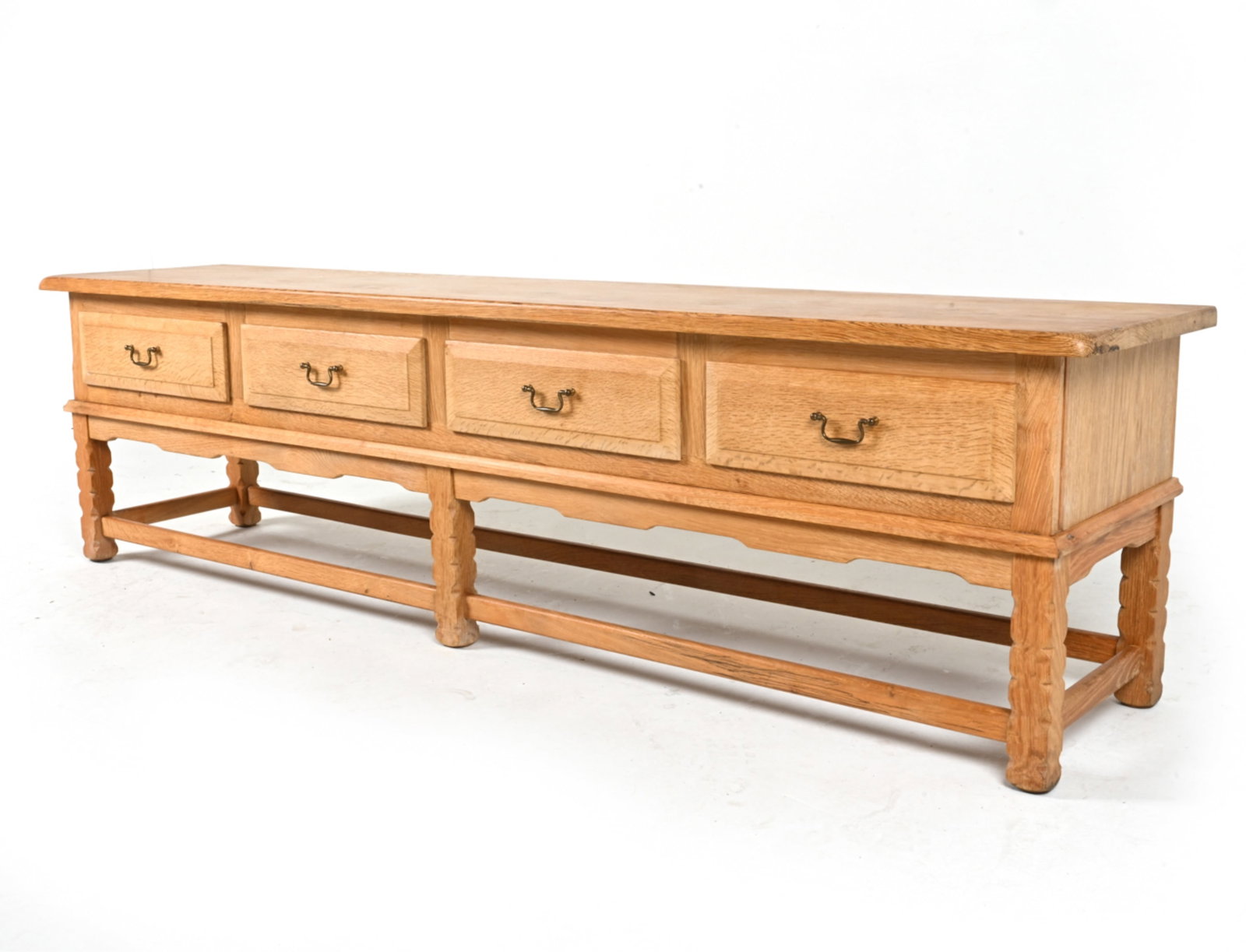 MANNER OF KJAERNULF DANISH LOW OAK SIDEBOARD: Circa 1970's. Dimensions: H 21.25" x W 78.75" x D 17.5" Conditions: Light surface wear consistent with age and use, a few scattered dings and scuffs. Faint water rings on top. DMG011