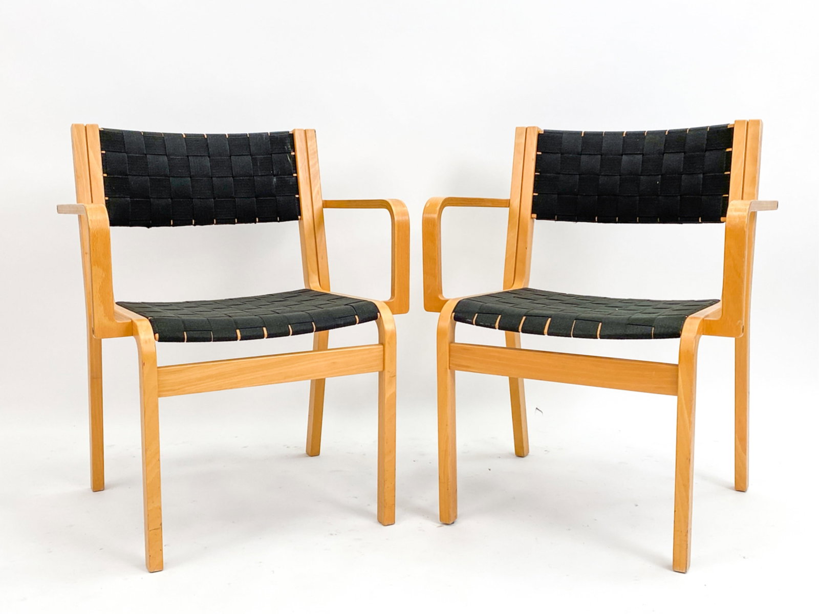 BENTWOOD ARM CHAIRS MANNER OF ALVAR AALTO: Pair of Alvar Aalto style arm chairs. Circa 1980s. Apparently unmarked. Dimensions: H 31.25' x W 24.25" x D 20" x SH 18" Conditions: Minor surface wear, scuffs, marks and scratches consistent with age