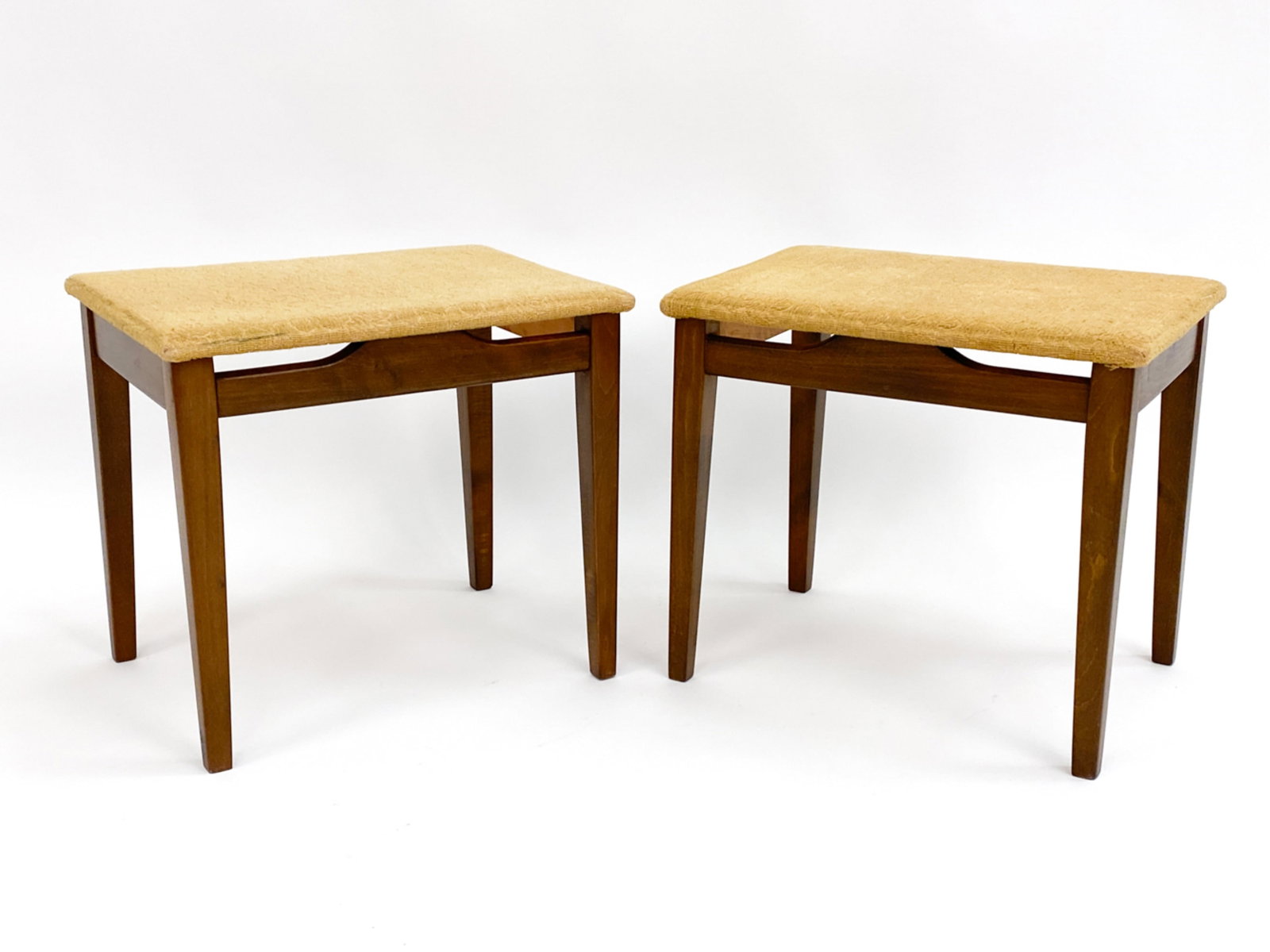 PAIR OF FINN JUHL STYLE BEECHWOOD FOOTSTOOLS: With floating seats, Circa 1960's. Apparently unsigned, remnants of a label underneath one. Fabric appears to be original. Dimensions: H 16.5" x W 18.5" x D 13.5" Condition: Wear consistent with age a