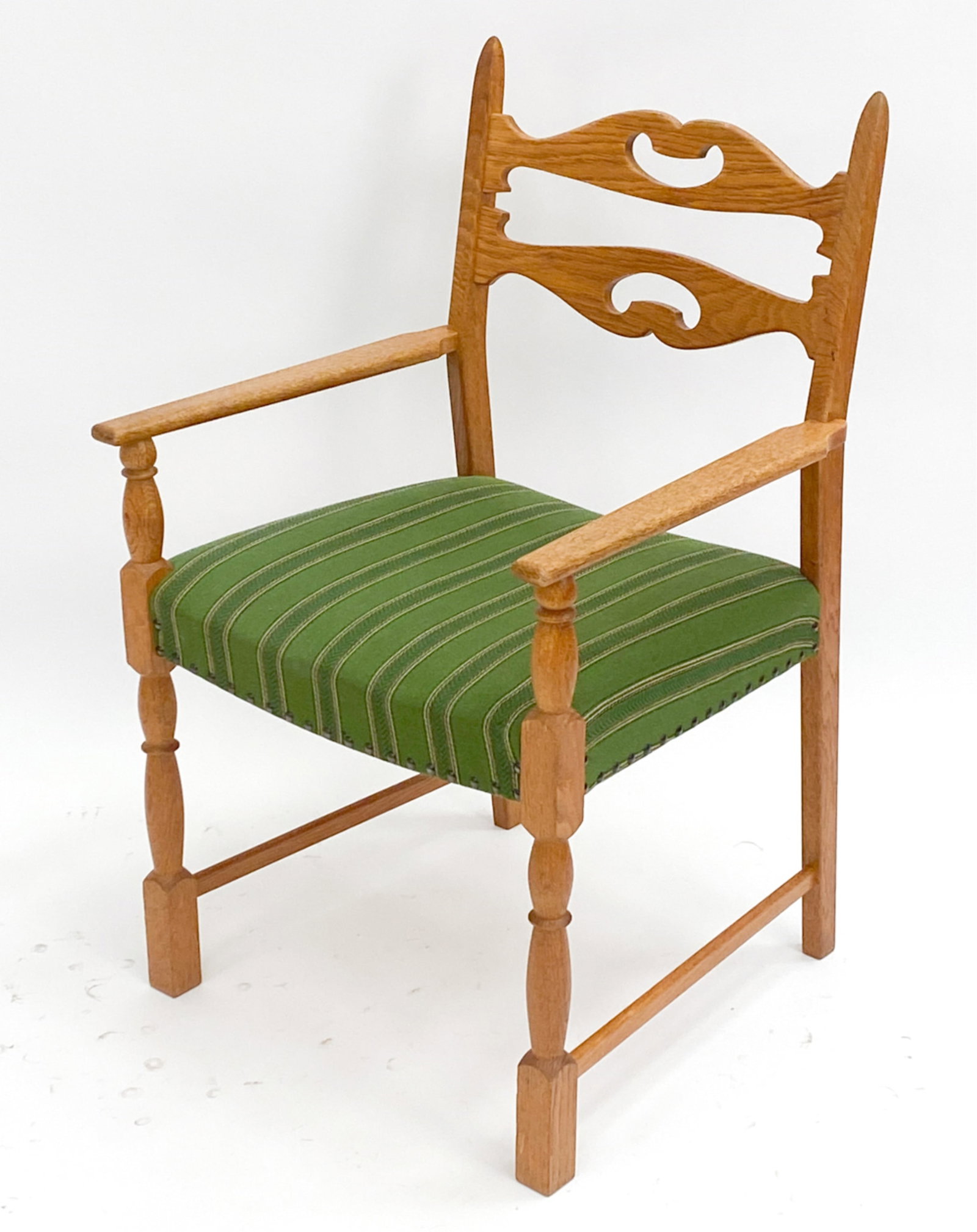 KJAERNULF STYLE DANISH OAK ARMCHAIR: Oak armchair in the style of Henning Kjaernulf, unsigned. Dimensions: H 36.25" x W 22.25" x D 20.5" x SH 18" Condition: Few scattered marks, one small chip repair to proper left side leg.