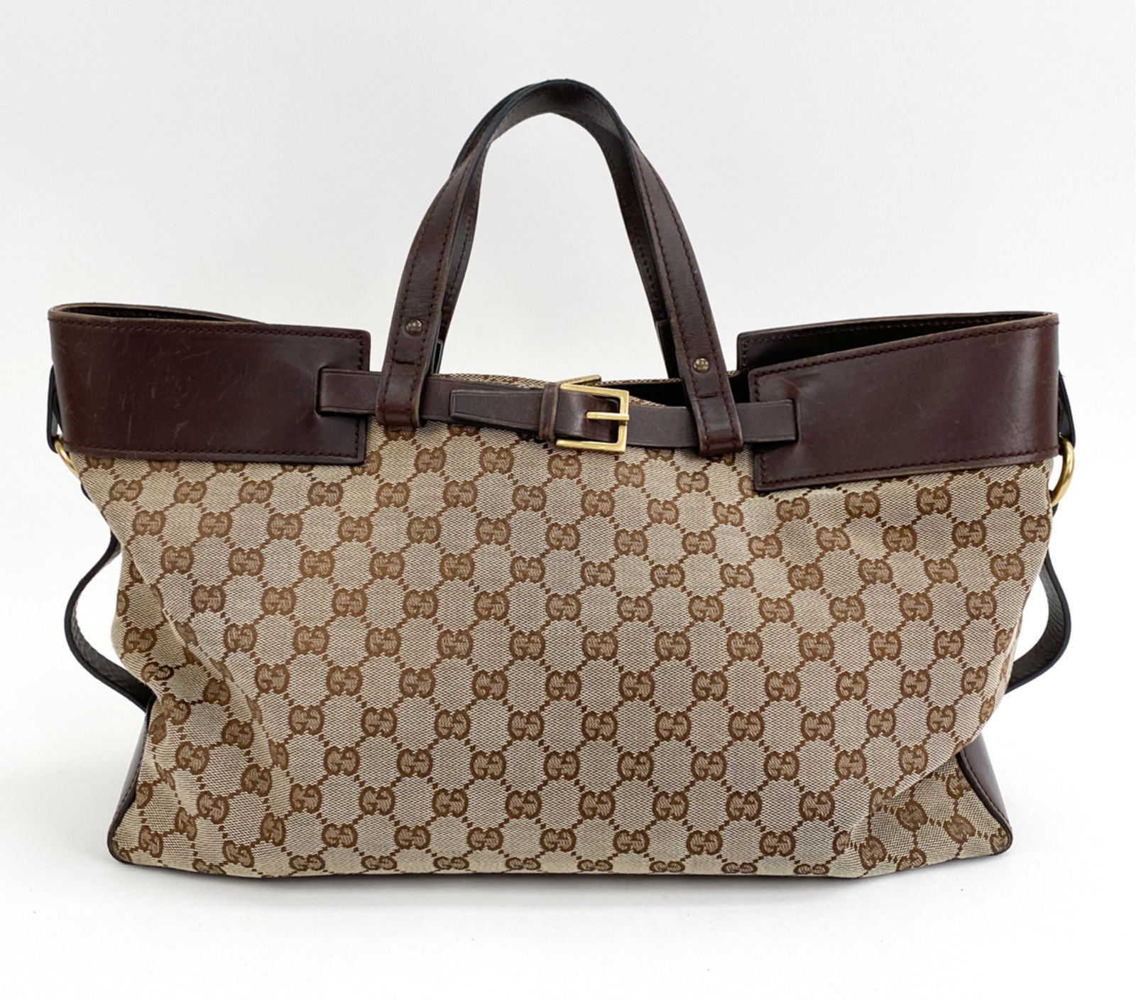 GUCCI LARGE BROWN CANVAS BUCKLE TOTE: Tote covered with GG canvas and goldtone hardware with leather straps and lining. Dimensions: H 10" x W 15.5" x D 5.5" Handle Drop 5.5" Condition: Some rubbing and scuffs to leather. Presents well ove