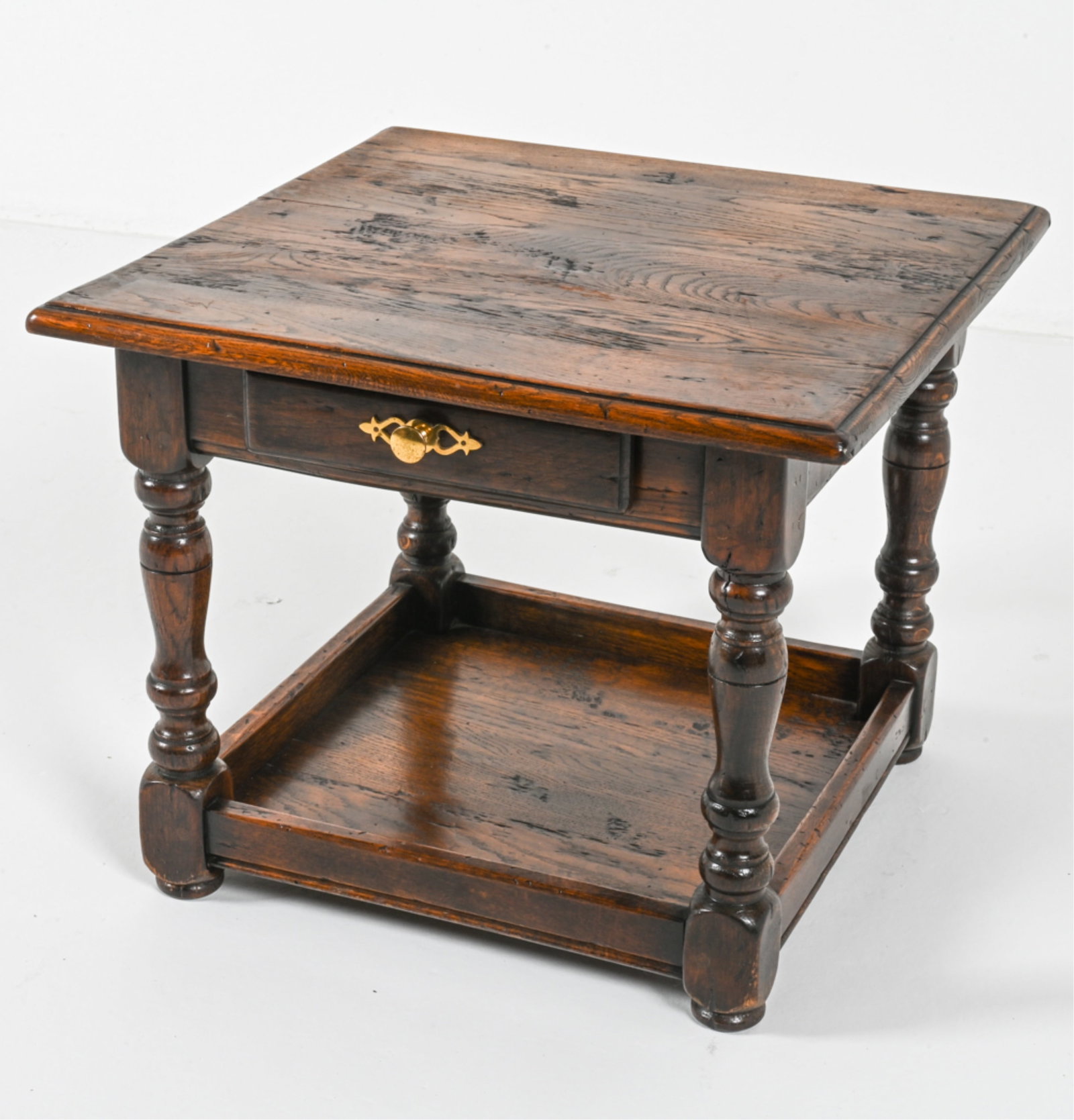 OAK SIDE TABLE: In dark espresso stain. Brass pull. Turned legs. Mid-20th century. Dimensions: H 17.5" x W 22" x D 21.5". Condition: Wear consistent with age and use. KON B023
