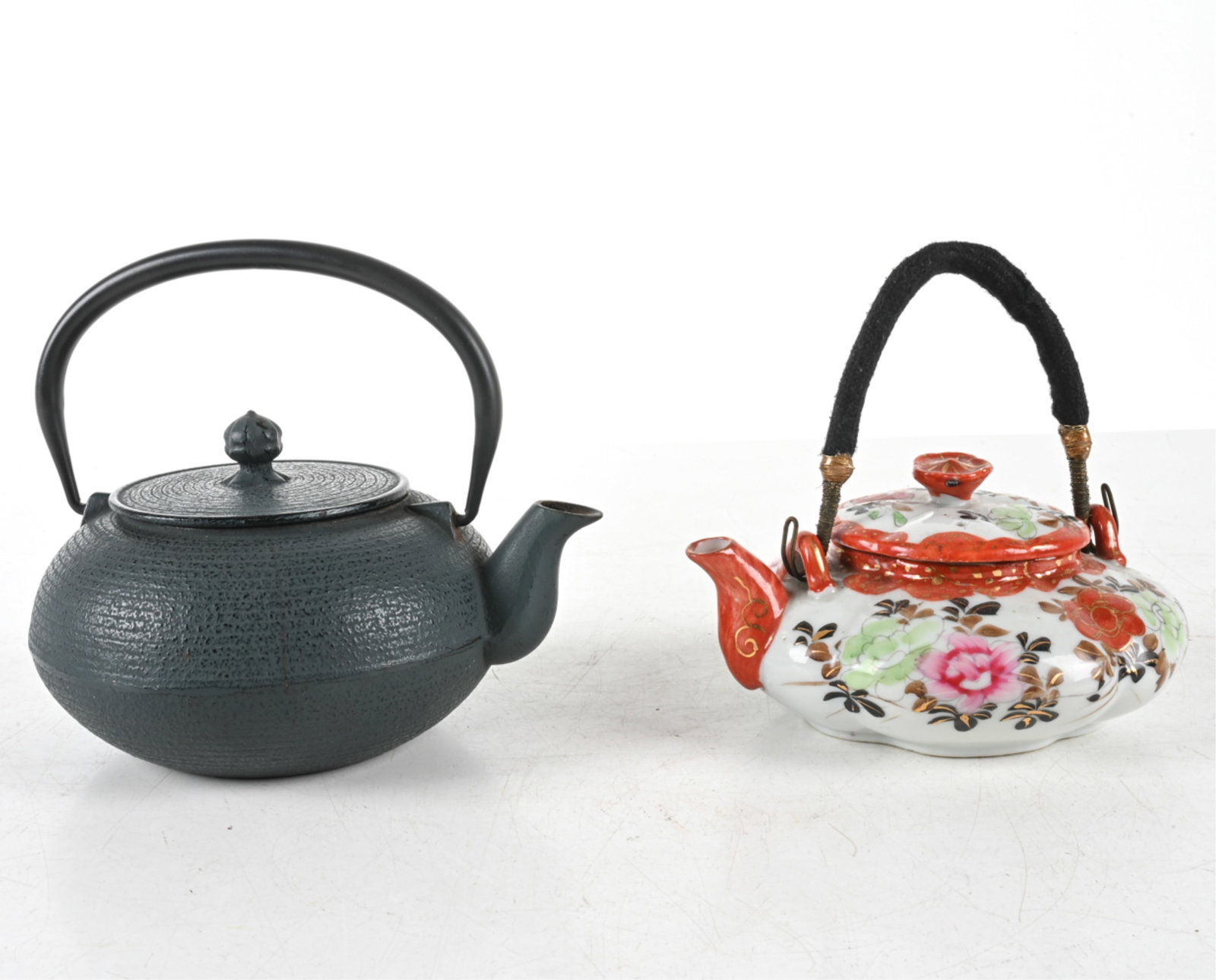 (2) TEAPOTS: Includes (1) painted ceramic teapot with fabric and wire-wrapped handle. Apparently unmarked. Together with cast-iron teapot with handle. Late 20th century. Dimensions: Iron Teapot H 4.5" x W 7.75" x