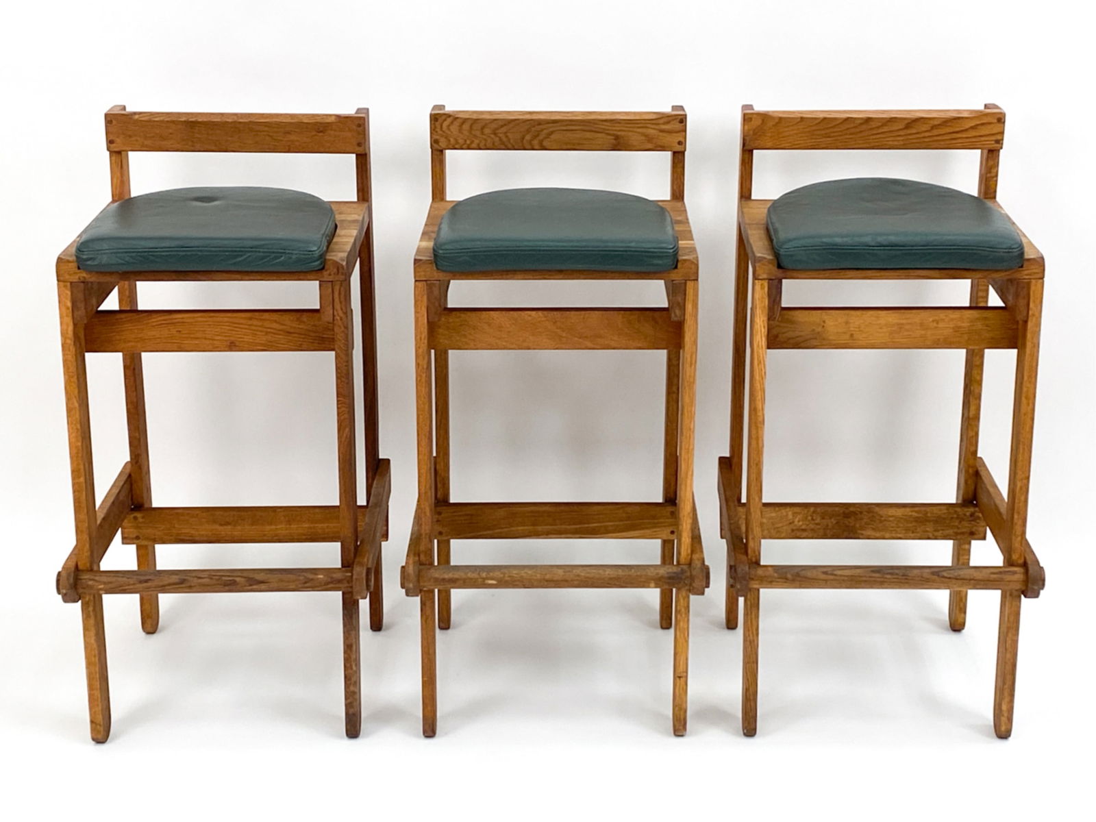 (3) PIERRE CHAPO STYLE ELM BARSTOOLS. C.1970'S: 3 Pierre Chapo style Elm barstools with green leather cushions. Seats have cut out indents to seat for leather cushions.Dimensions: H 35" x W 16" x D 18" x SH 29.5"Condition: Marks to wood. Soiling an