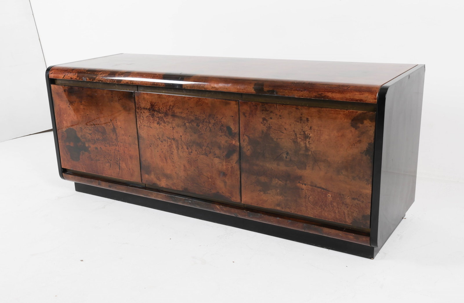GOATSKIN CREDENZA BY ALDO TURA , CIRCA 1970'S: Lacquered goatskin credenza with (3) drawers. Lacquered stone on sides. Italy. Dimensions: H 28.5" x W 70.75" x D 23.5". Condition: Scratches and scuffs to lacquered finish. Small chip to side stone p