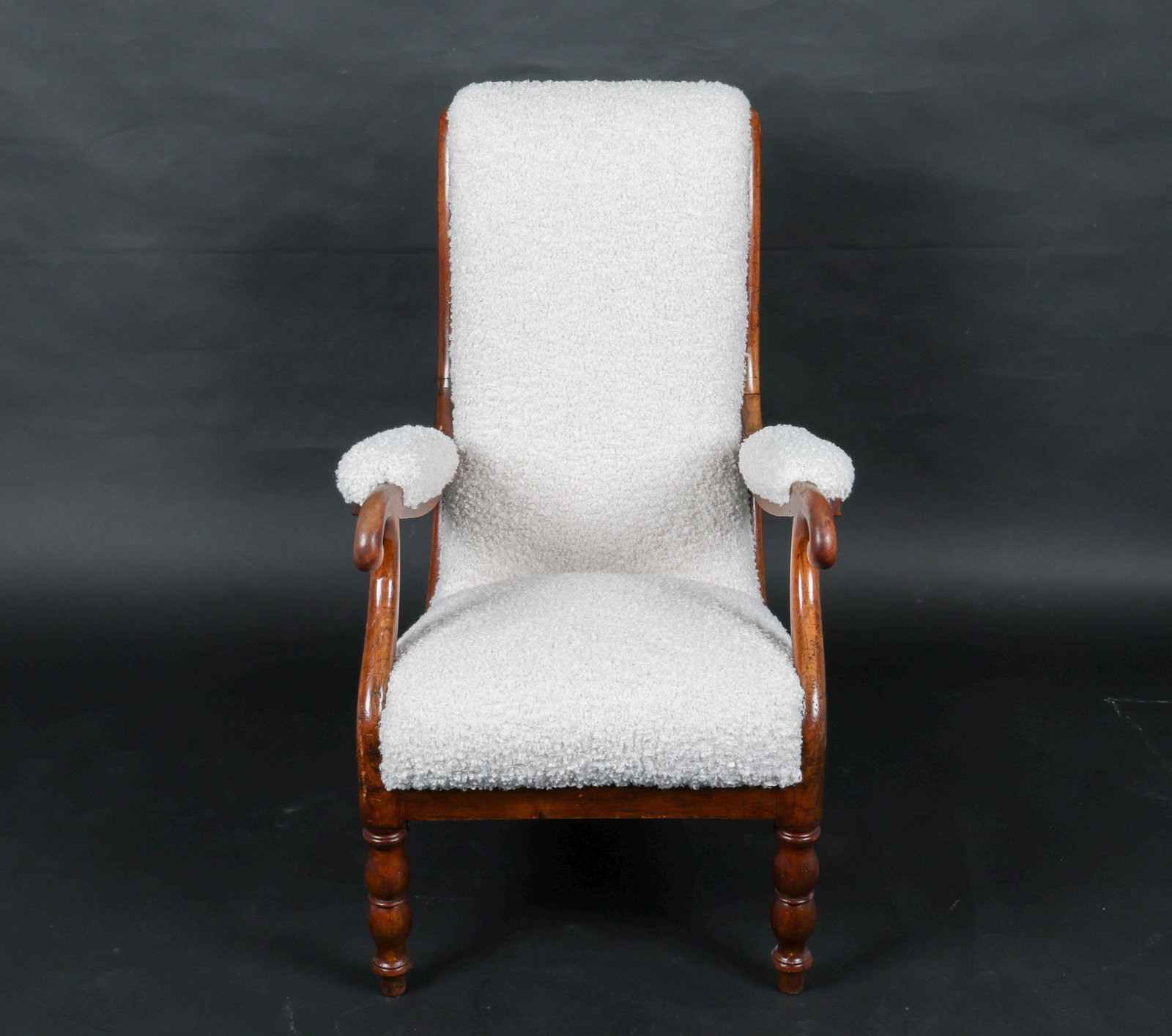 ANTIQUE MAHOGANY AND BOUCLE ARMCHAIR: Carved and shaped arms, turned legs. Empire style. European, Early 20th century. Dimensions: H 38.25" x W 24.5" x D 25.25" x SH 17.5". Condition: New upholstery. Old scratches, some nicks and areas of