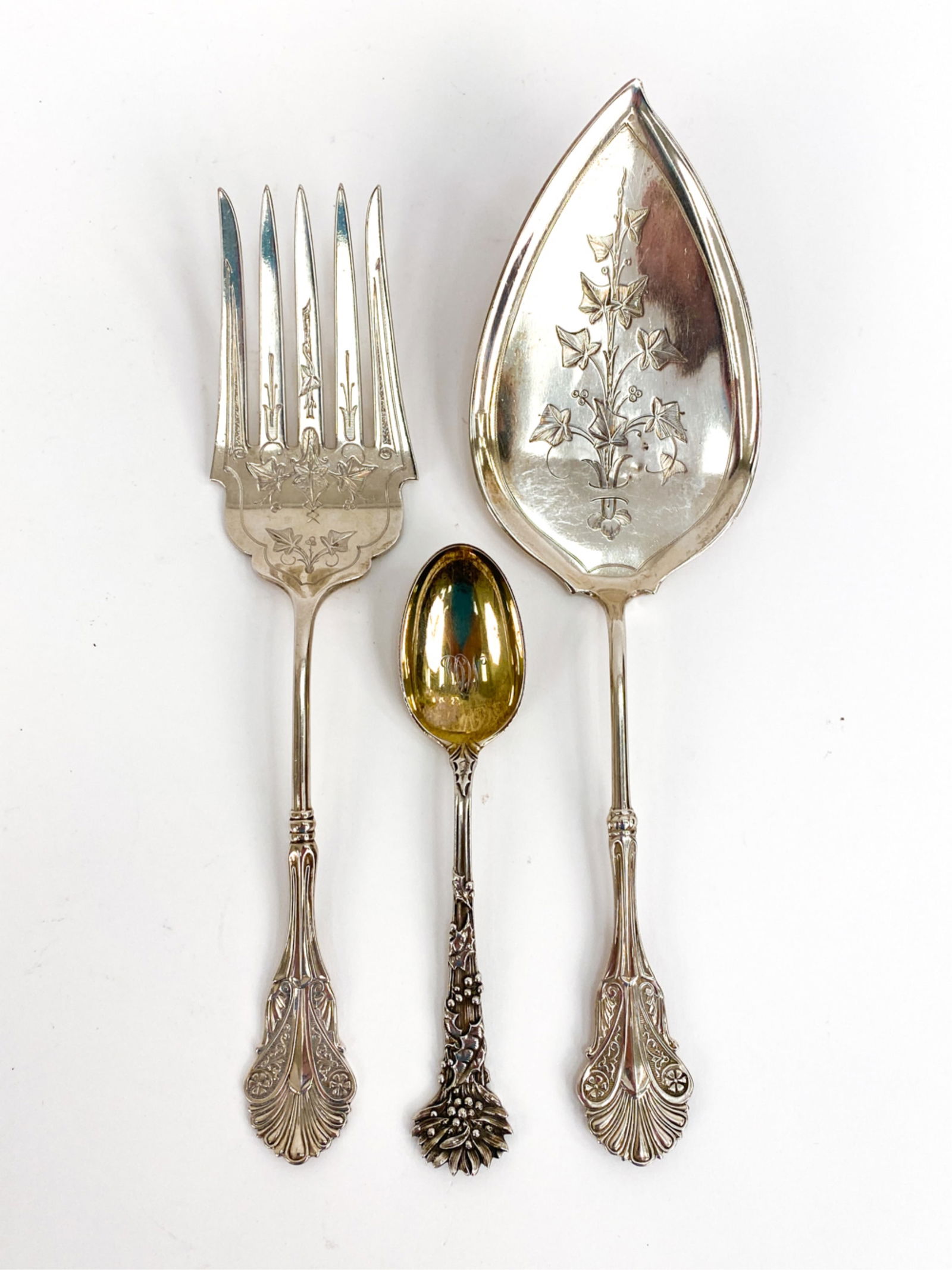 ANTIQUE TIFFANY MAKERS STERLING SILVER SERVEWARE: 3 antique Tiffany & Co Sterling Serveware. All marked on bands. 1 Pie server, 1 5 tine serving fork, both with scalloped ends to handles. 1 table spoon with monogram and floral end to handle. Dimensio