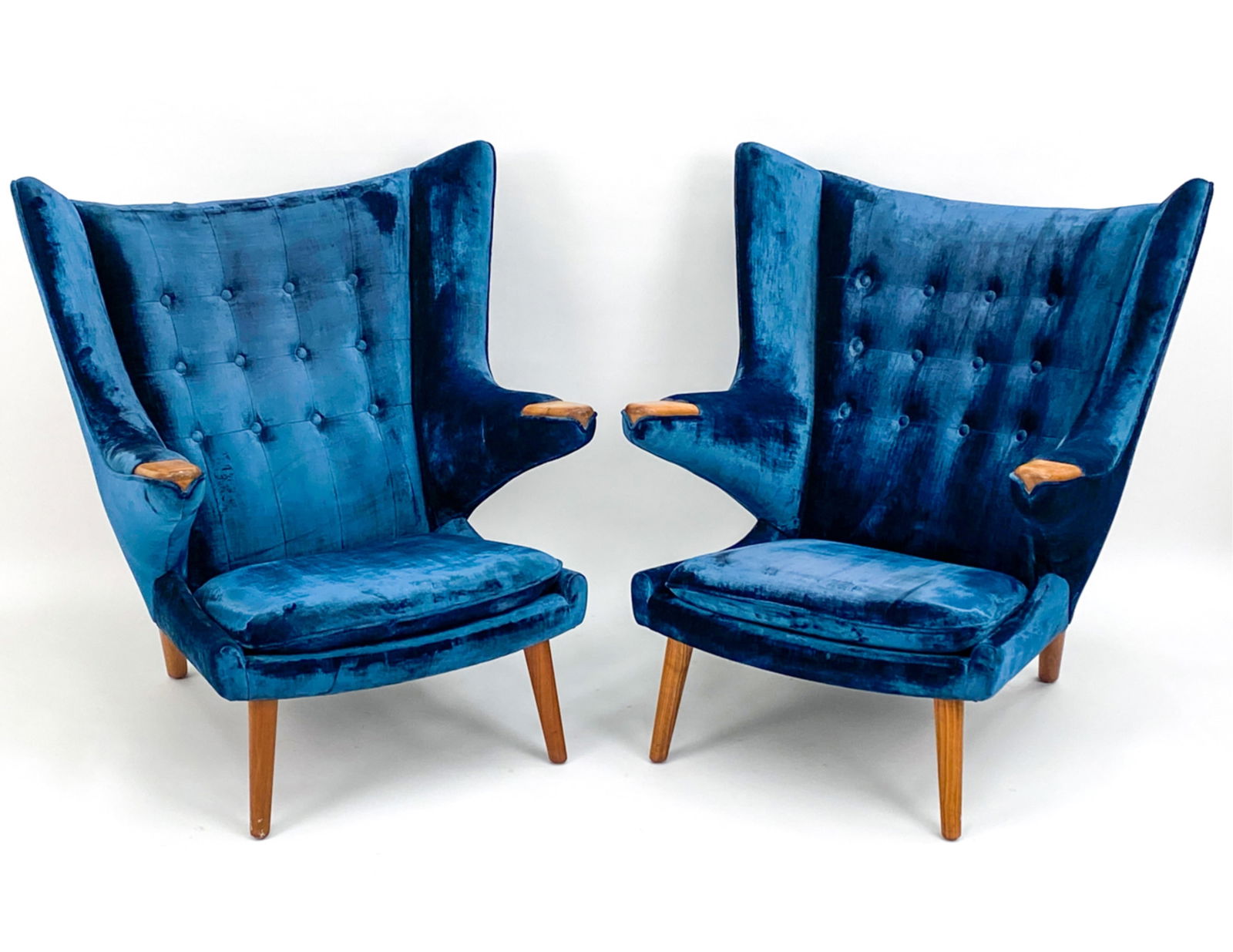 PAIR HANS WEGNER FOR MODERNICA PAPA BEAR CHAIRS: Blue velvet chairs with wooden arms and legs. Labeled to underside Dimensions: H 36" W 30" D 24" SH 16" Condition: Wear to areas to fabric consistent with age and use.