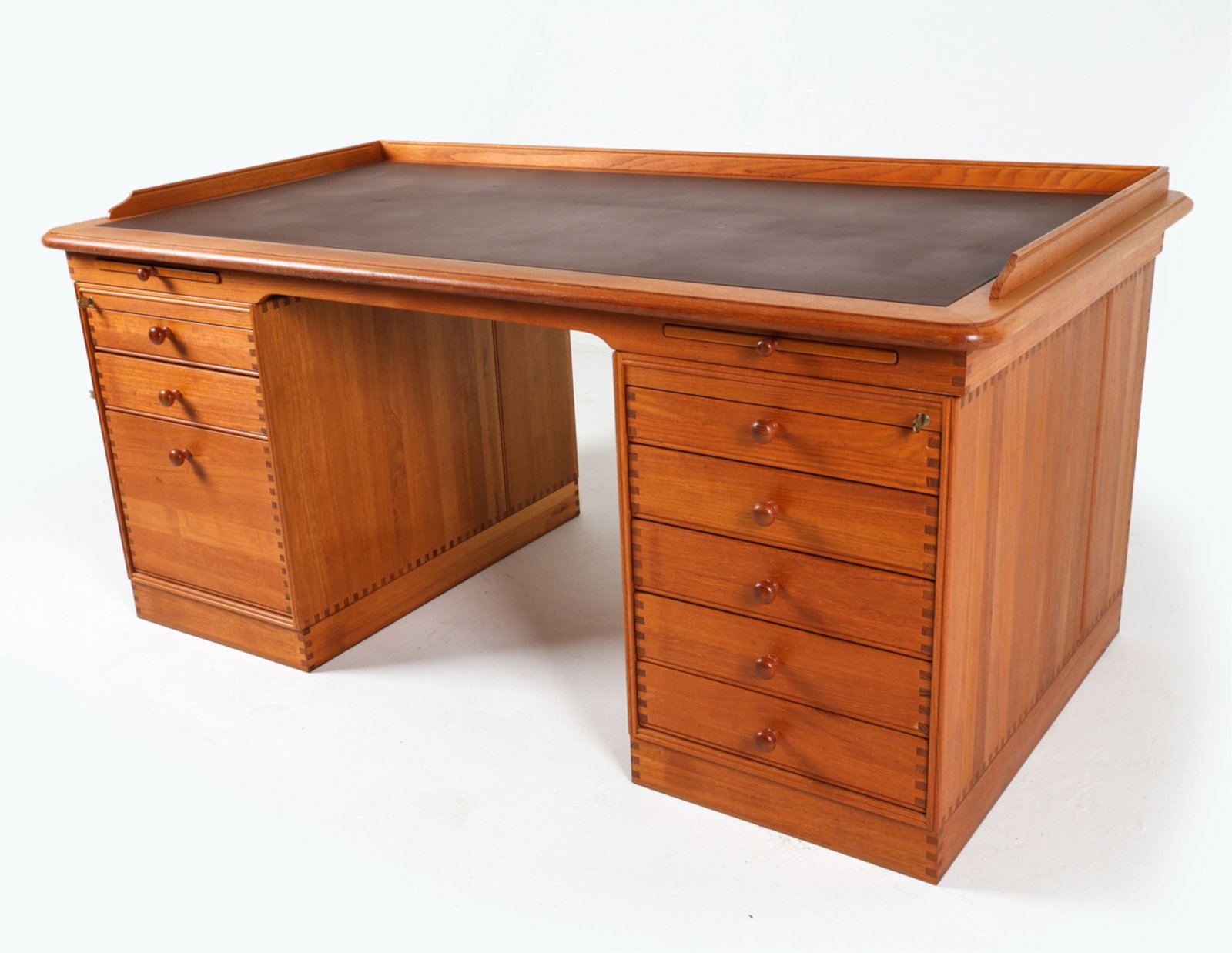 DANISH TEAK DIRECTOR'S DESK, CIRCA 1970'S: Inlay leather top. Beautiful box-hinges on sides, drawers. (2) keys included. Adjustable shelves. Dimensions: H 30.5" x W 66.5" x D 35.25". Condition: Small scuffs and dings to leather. Burn mark to l