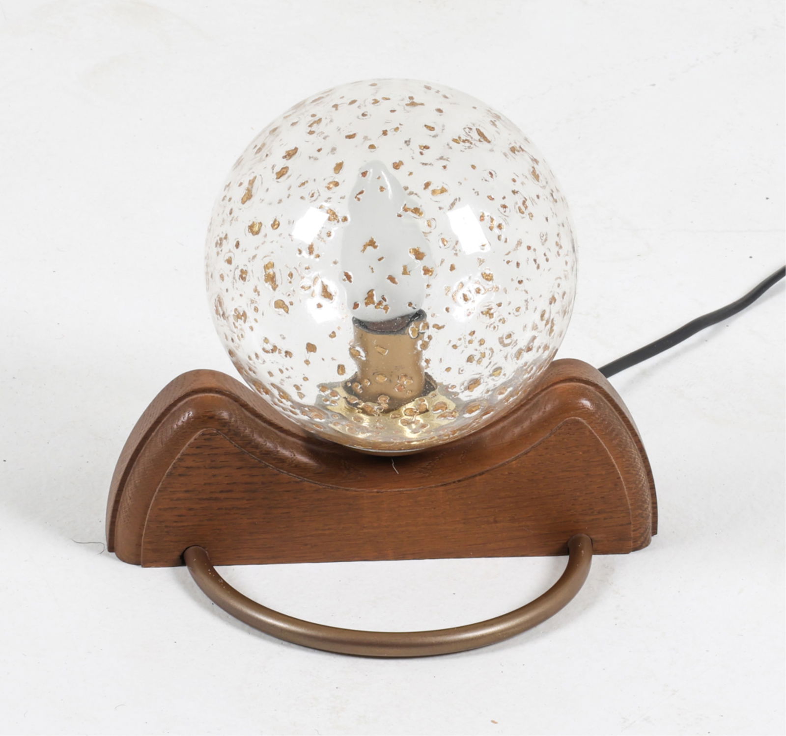 GLOBE SHADE WALL SCONCE FOR TEMDE, C.1970'S: Ice glass globe shade. Oak brace with brass accent handle. Switzerland. Dimensions: H 6.75" x W 9" x D 8". Condition: Wiring untested, European plug - requires adapter or rewiring for use in the US. P
