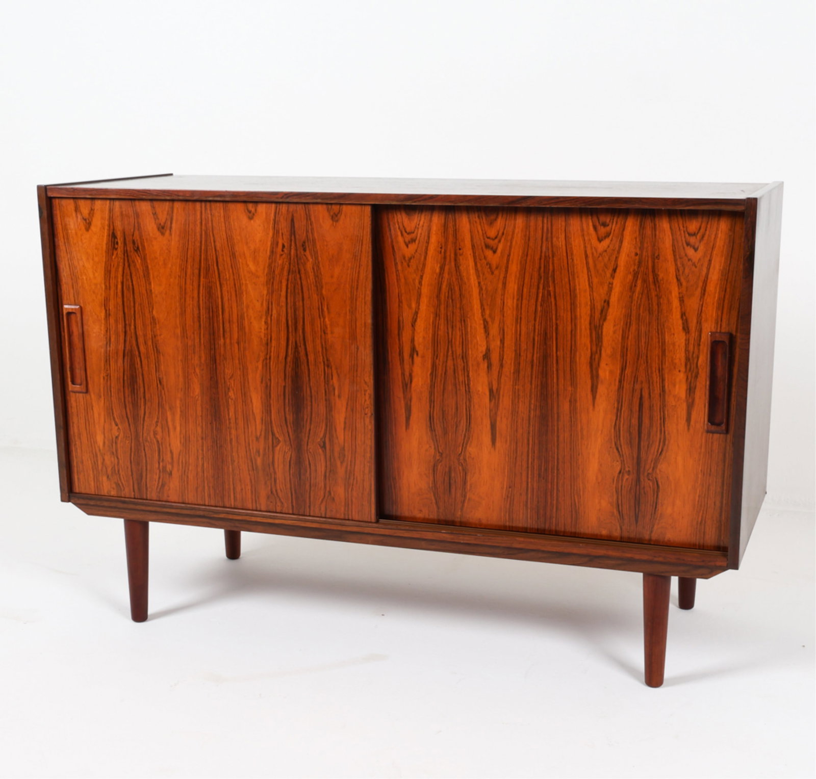 DANISH ROSEWOOD CREDENZA CABINET, CIRCA 1960'S: With sculpted rectangular cabinet door pulls. Tapered legs. Adjustable shelves. Dimensions: H 30.75" x W 47.25" x D 17.25". Condition: Legs may not be original. Some minor scrapes on top, pictured. We