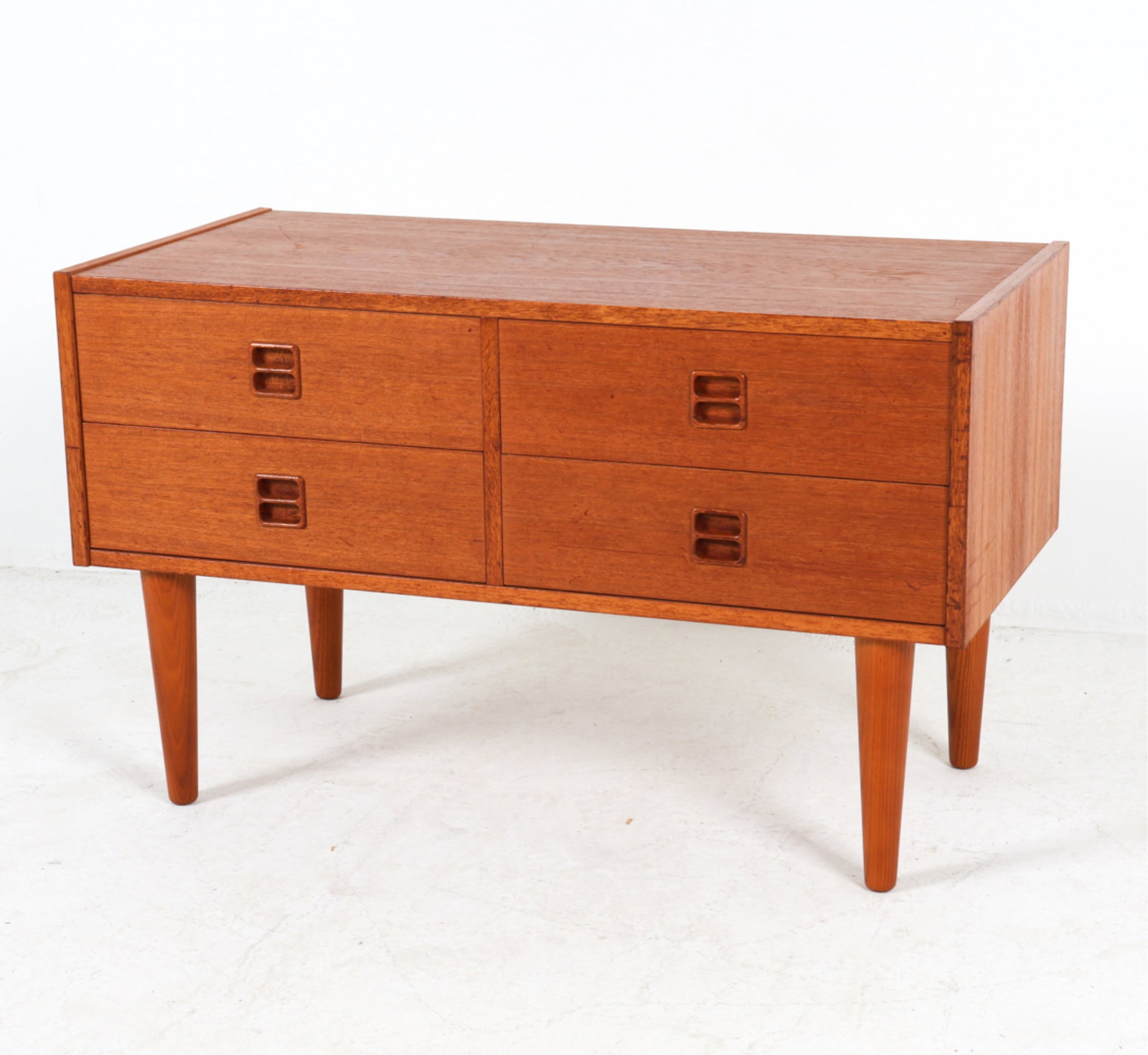 DANISH TEAK LOW CHEST, CIRCA 1960'S: Carved inset drawer pulls. Dimensions: H 21.25" x W 34.5" x D 16.75". Condition: Scattered scuffs and dings, wear consistent with age and use. Grouping of dings on corner, pictured. DMI111