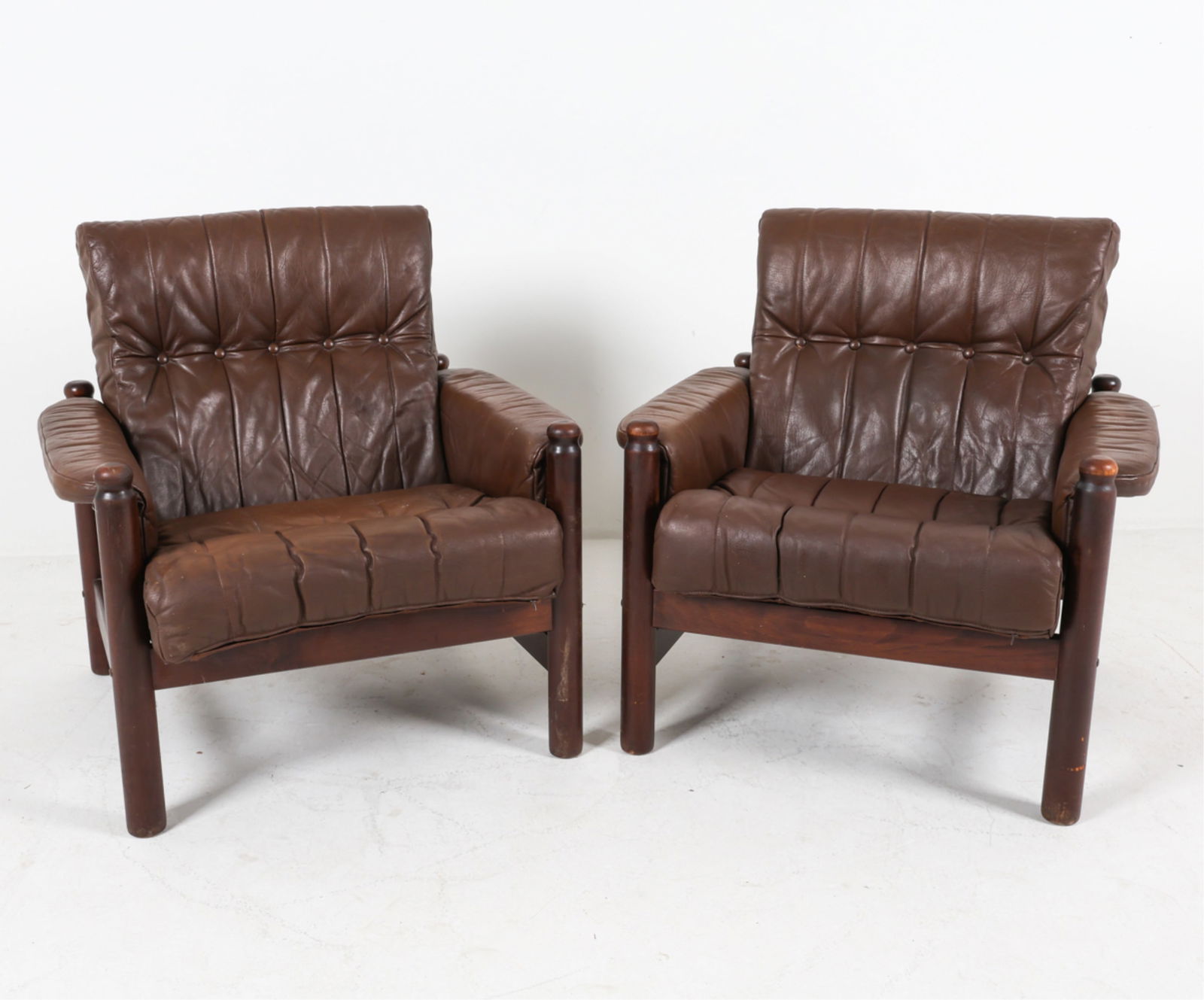 (2) DANISH LEATHER LOUNGE CHAIRS C.1950'S: Leather upholstery. Espresso stained beech frame. Style of Arne Norell. Dimensions: H 34" x W 33" x D 41.5" x SH 17". Condition: Wear consistent with age and use, Marks and discoloration to leather. N