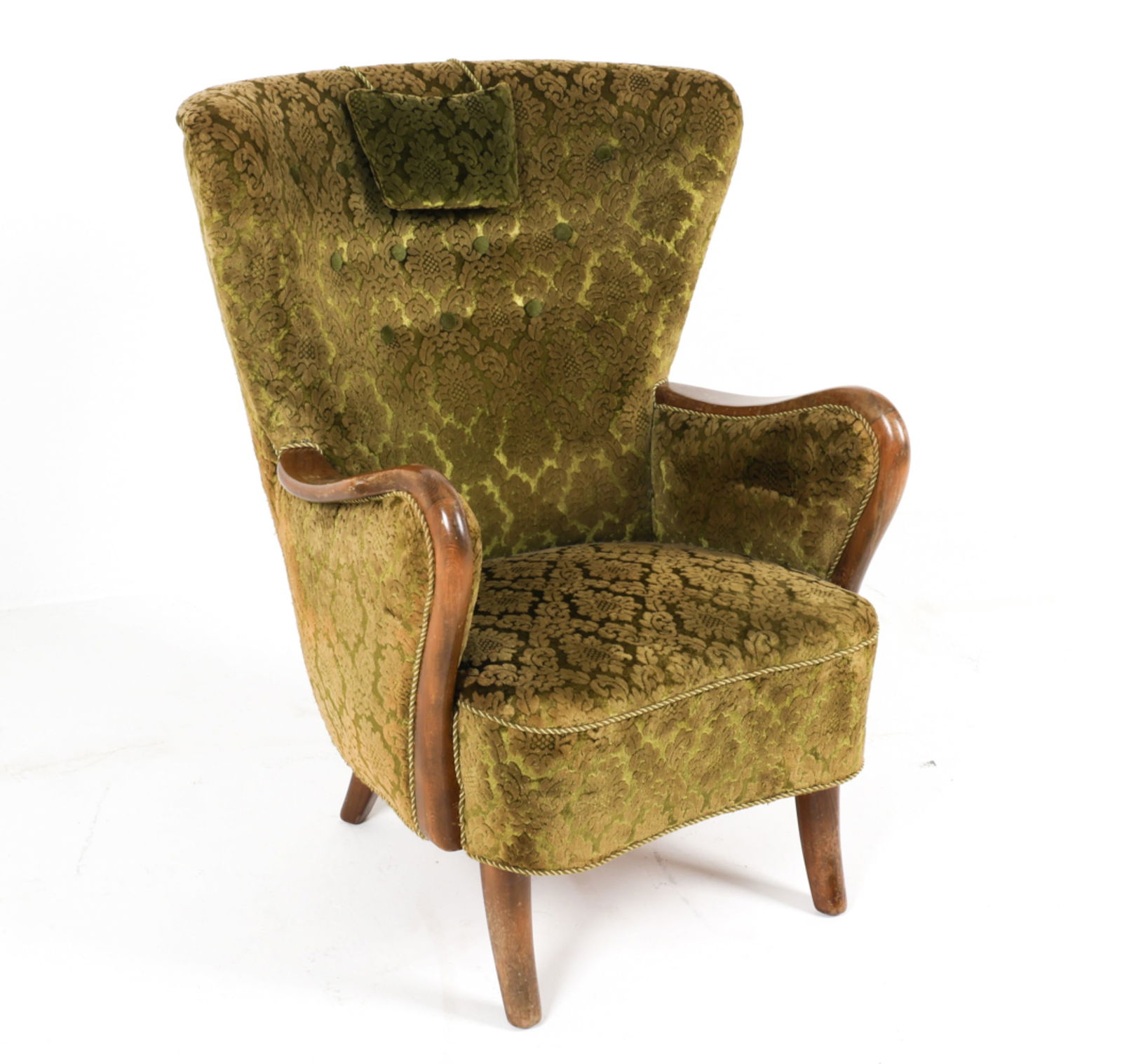 DAINSH VELVET WINGBACK ARMCHAIR, C.1950'S: Green cut-velvet upholstery with damask design. Exposed oak wood arms, sculptural curves. Dimensions: H 37.25" x W 28" x D 28.5" x SH 16.25". Condition: Minor signs of wear to velvet. Some rubs and sc