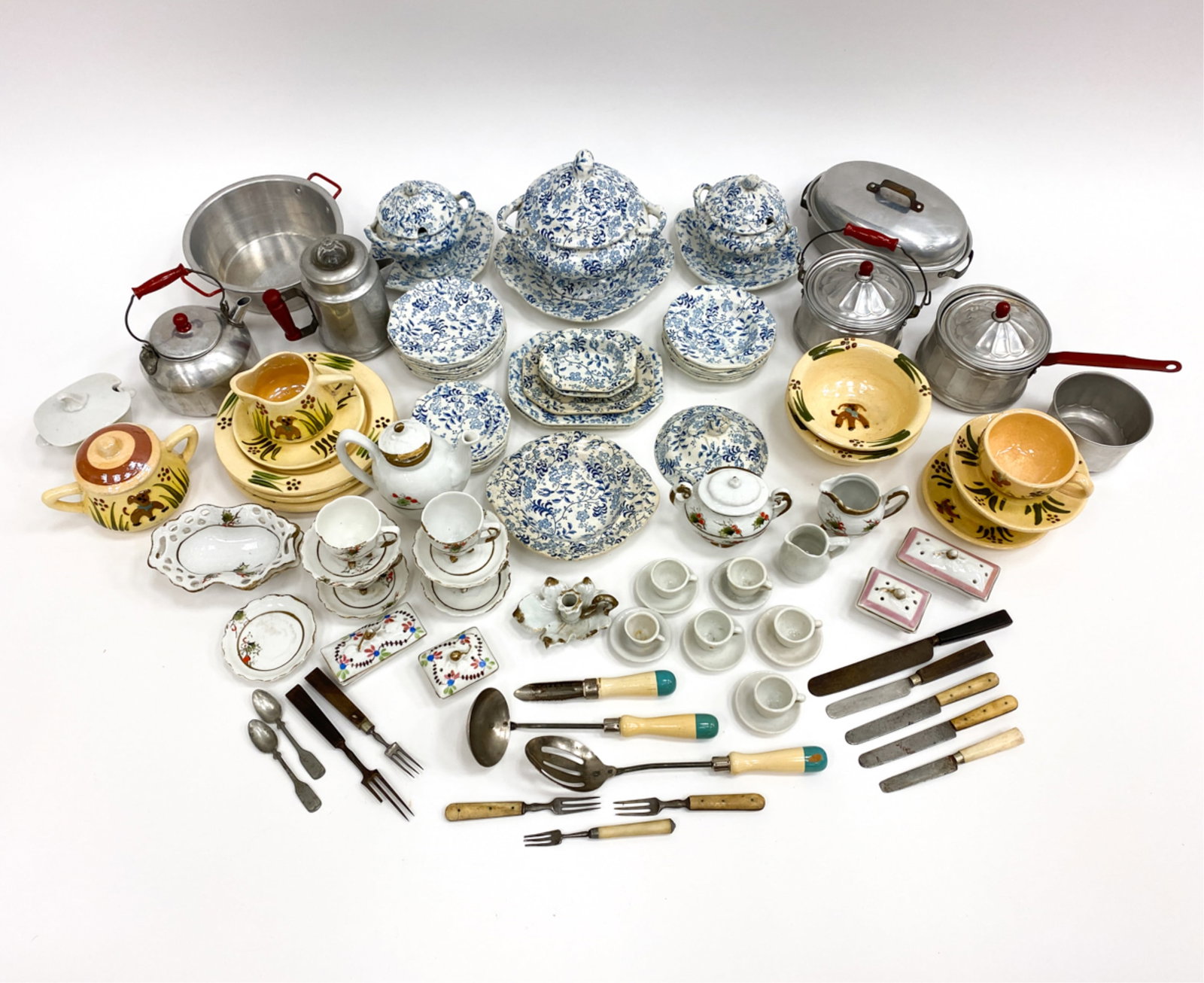 PORCELAIN & TIN DOLL HOUSE TEA SERVICE: Doll tea service in ceramic, porcelain and aluminum. 12 Yellow ceramics with hand painted exteriors. 32 White ceramics with blue floral motifs 7 pieces of aluminum. 43 white porcelain with hand painte