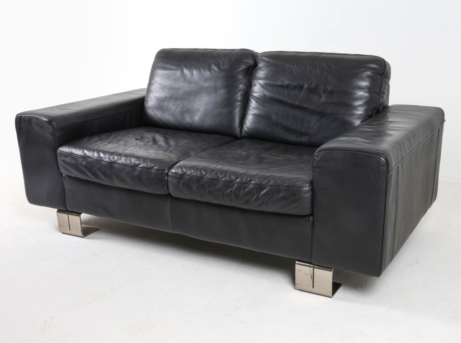ITALIAN BLACK LEATHER SOFA BY NATUZZI: On square-shaped steel legs. Early 2000's. Dimensions: H 31" x W 67" x D 36" x D 16.5". Condition: Minor signs of wear to leather. Some scuffs and scratches to legs. Wear consistent with age and use.