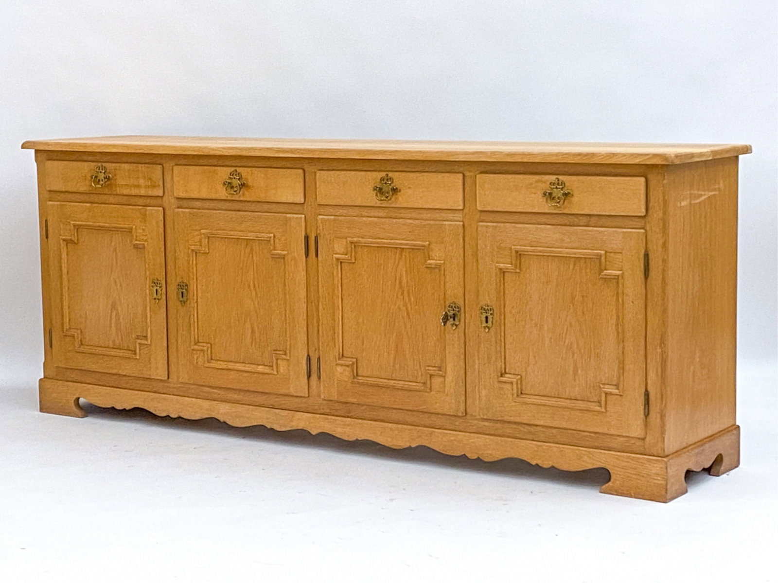 DANISH OAK SIDEBOARD MANNER OF KJAERNULF: (1) Key. Brass fittings. Dimensions: H 31" x D W 79" x D 17.5" Condition: Minor blemishes to interior cabinets. Wear consistent with age and use F155