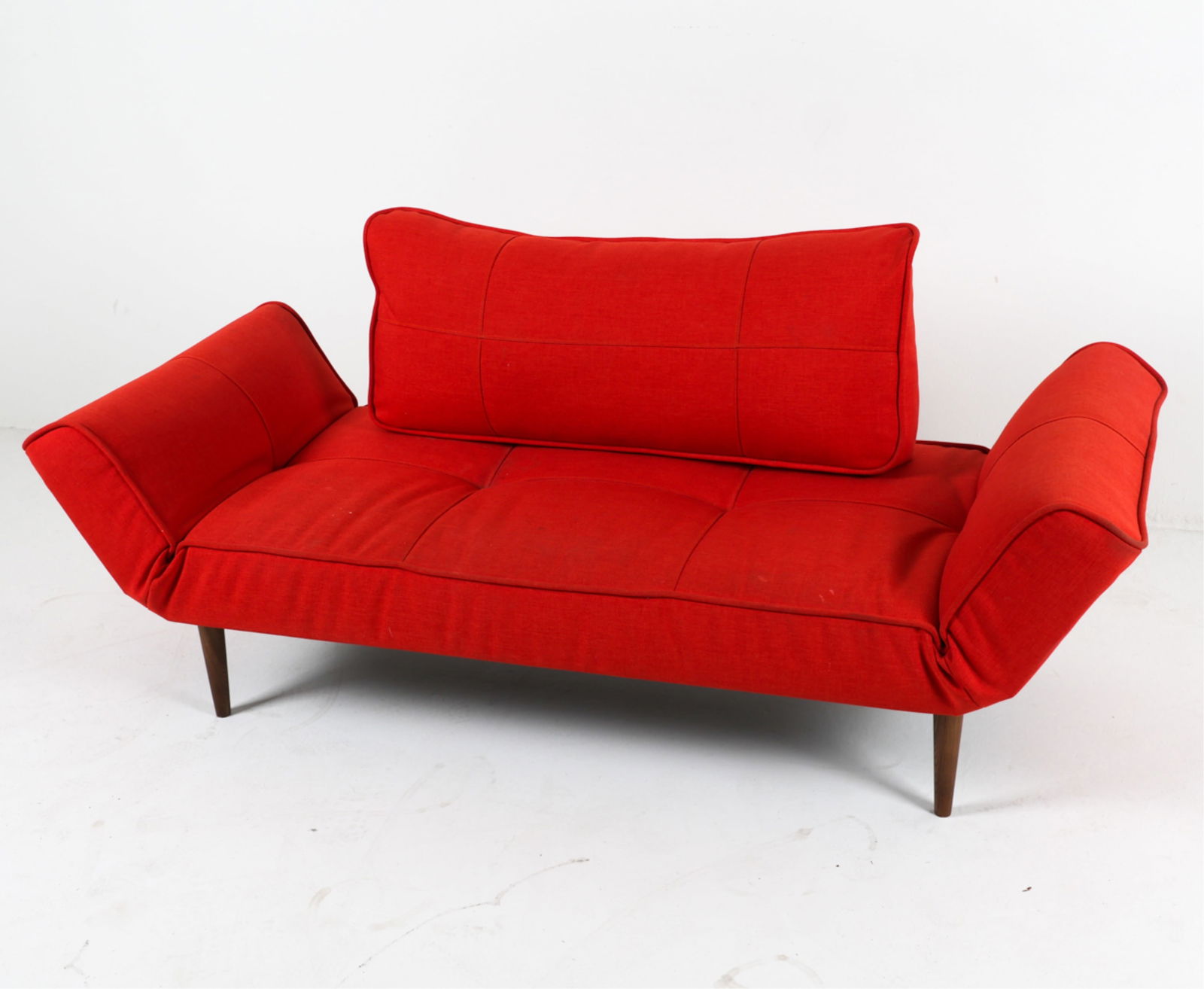 RED DAYBED SOFA BY PER WEISS: From Innovation Living. With metal brace seat back. Fabric upholstery. Tapered legs. Arms adjust to lay flat. Contemporary. Dimensions: As shown H 24" x W 67" x D 27.75" x SH 14.5". Condition: Some sm