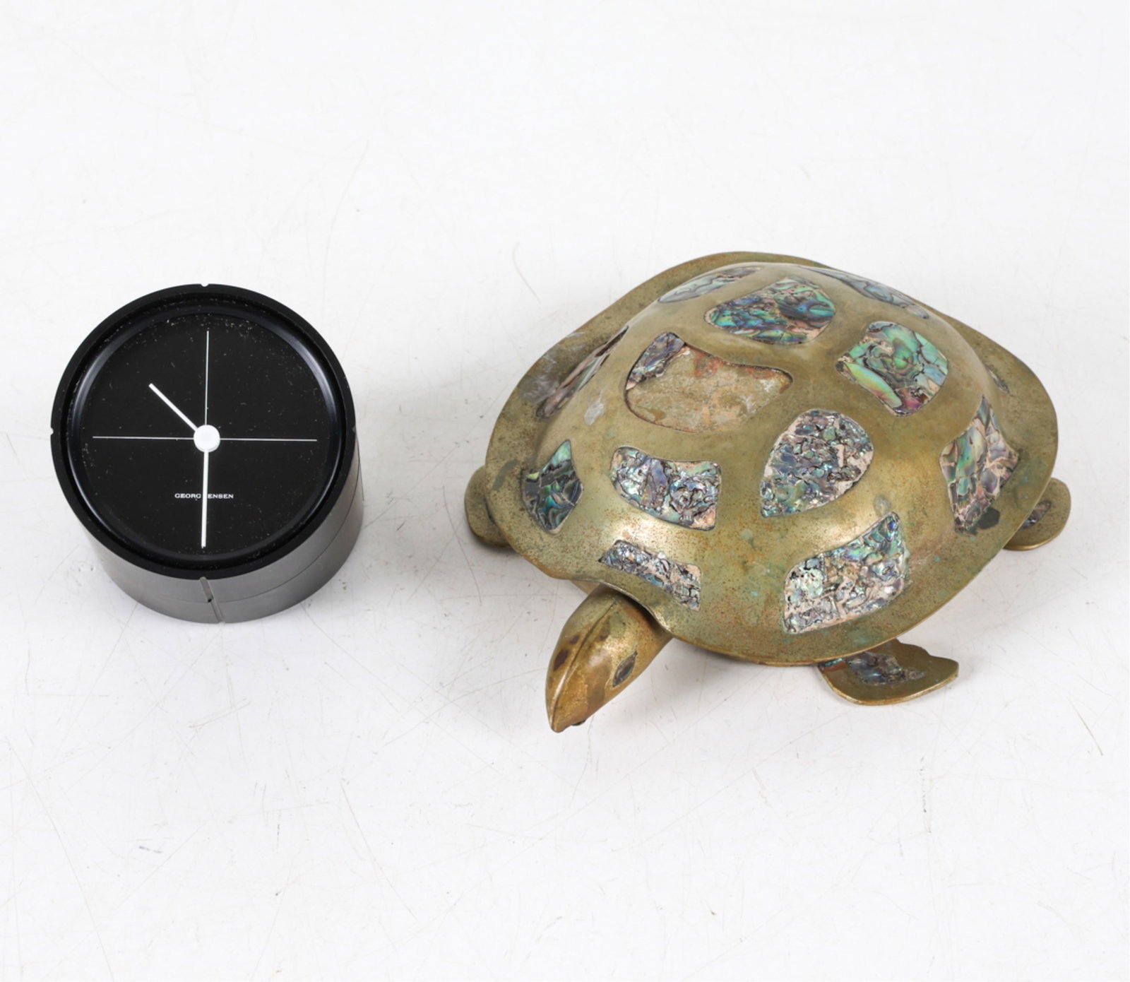 GROUPING INCLUDING GEORG JENSEN CLOCK: Includes table clock by Jorgen Moller for Georg Jensen, Denmark. Mexican brass turtle container with 'mother of pearl' inlay. Dimensions: Clock H 3.25" x W 4" x D 2.5". Condition: Timekeeping untested