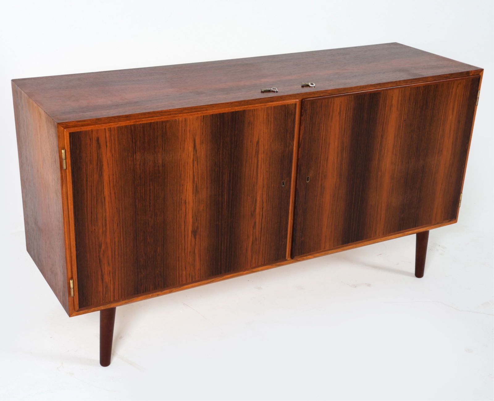 DANISH ROSEWOOD SIDEBOARD CREDENZA, C.1960'S: Key included. Legs can be removed. Shelves adjustable. Dimensions: H 29.5" x W 54.5" x D 17". Condition: Lock on right door may need servicing. Wear consistent with age and use. DMJ060