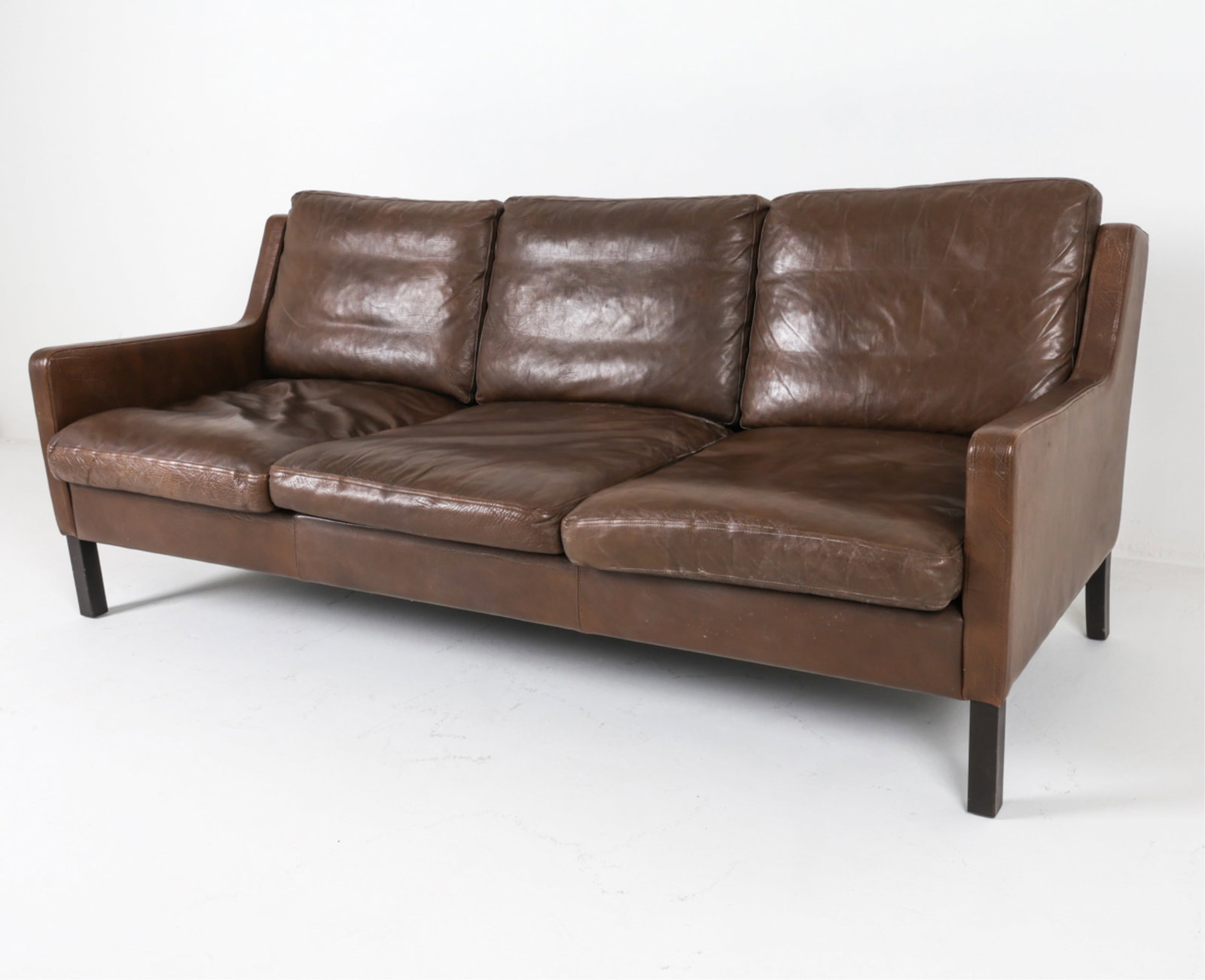 MID-CENTURY DANISH LEAHTER SOFA, CIRCA 1960'S: Dimensions: H 32" x W 75" x D 31" x SH 15.5". Condition: Minor signs of wear to leather cushions, some drying, light scratches. Wear consistent with age and use. DMJ143
