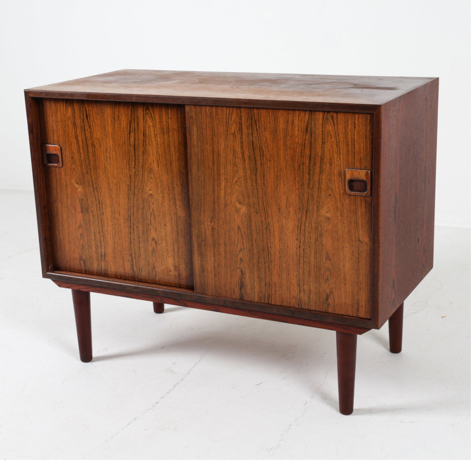 DANISH ROSEWOOD CABINET, C.1960'S: Molded square inset cabinet door pulls. Dimensions: H 27" x W 34" x D 16.5". Condition: Some sun fading on top, faint water rings. Wear consistent with age and use. DMJ167