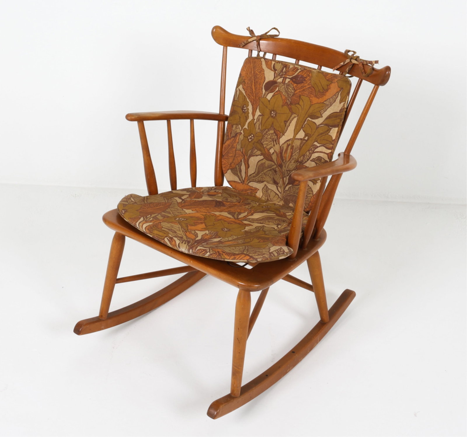 DANISH ROCKING CHAIR, CIRCA 1960'S: Spindle-back. With fabric seat cushions. Dimensions: H 32.25" x W 21.25" x D 28.5" x SH 16". Condition: Missing one rubber strap in seat, pictured. Spots of discoloration, scattered dings and scuffs. 