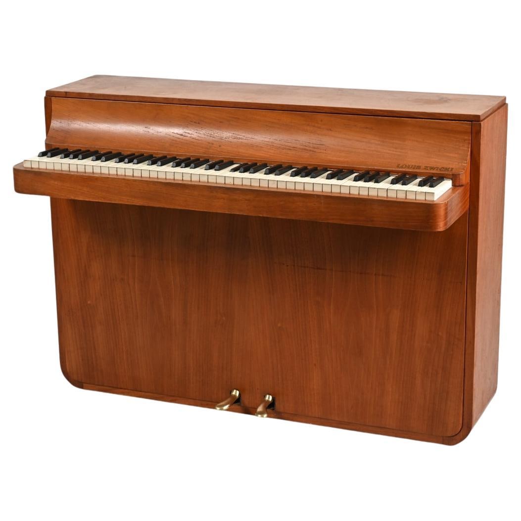 MID-CENTURY TEAK PIANETTE PIANO BY LOUIS ZWICKI: Step back in time with this masterfully-crafted Danish Mid-Century Teak Pianette by the renowned Louis Zwicki. From the heart of the 1960's, a period when design and craftsmanship merged in perfect ha