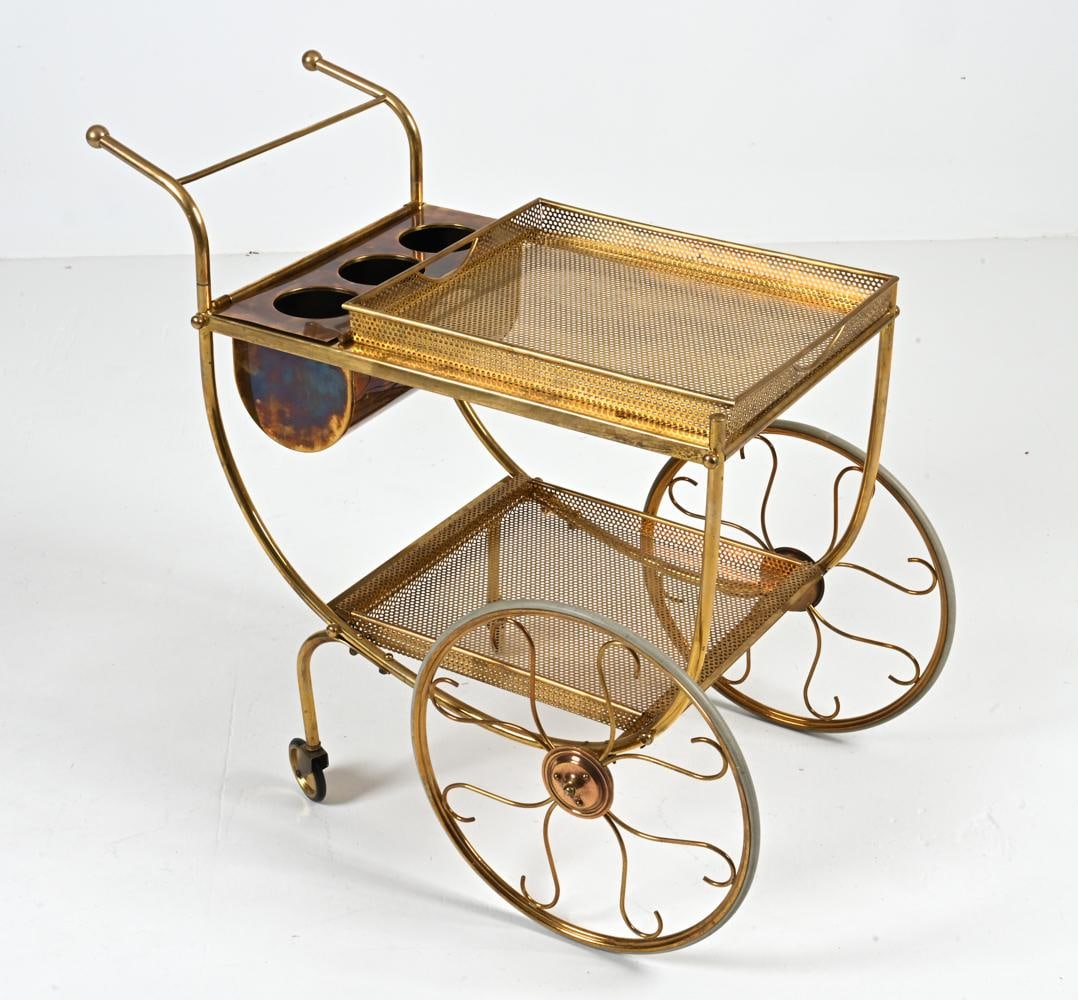 BRASS BAR CART BY JOSEF FRANK FOR SVENSKT TENN.: Channel Old Hollywood glamour with this fantastic and rare serving trolley designed by Josef Frank for Svenskt Tenn. Crafted from pierced brass with scrolled wirework decorating its dramatically overs