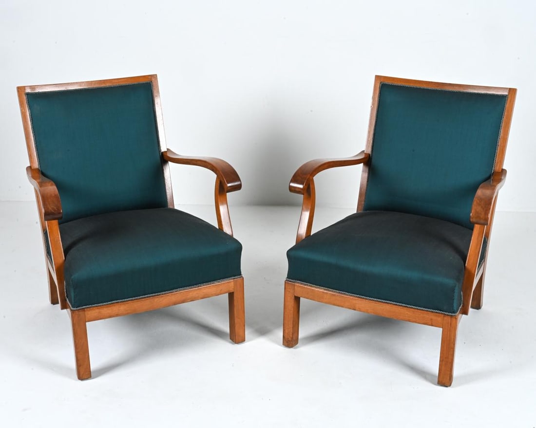 PAIR OF MAHOGANY LOUNGE CHAIRS BY ERIK WORTS: Introducing a rare and exquisite pair of open-arm lounge chairs designed by the renowned Danish craftsman, Erik Worts, and meticulously produced in Denmark during the 1950's. These exceptional chairs